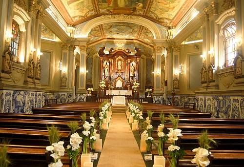 Uma igreja é decorada com flores e velas para uma cerimônia de casamento.
