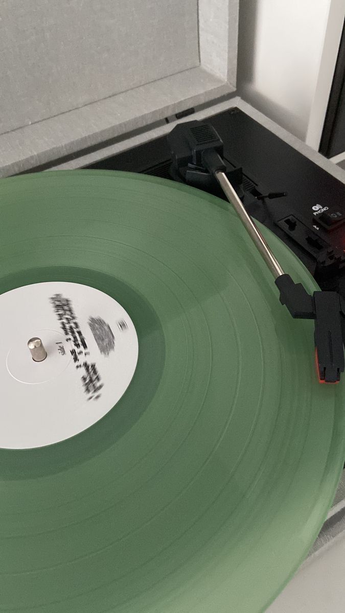 Um disco verde está sendo tocado em um toca-discos.