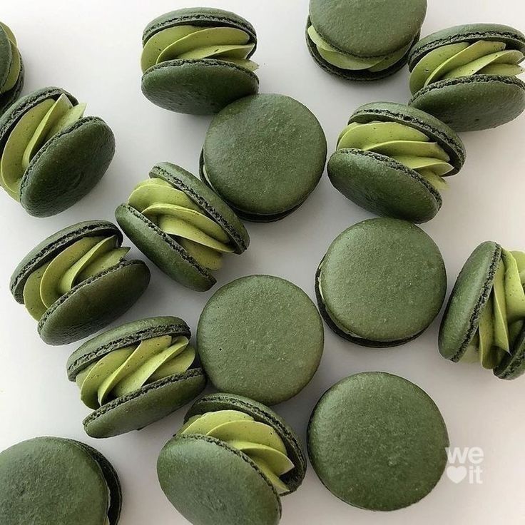 Um monte de macarons verdes estão sobre uma mesa