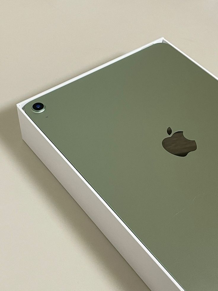 Um iPad verde da Apple está em uma caixa branca sobre uma mesa.