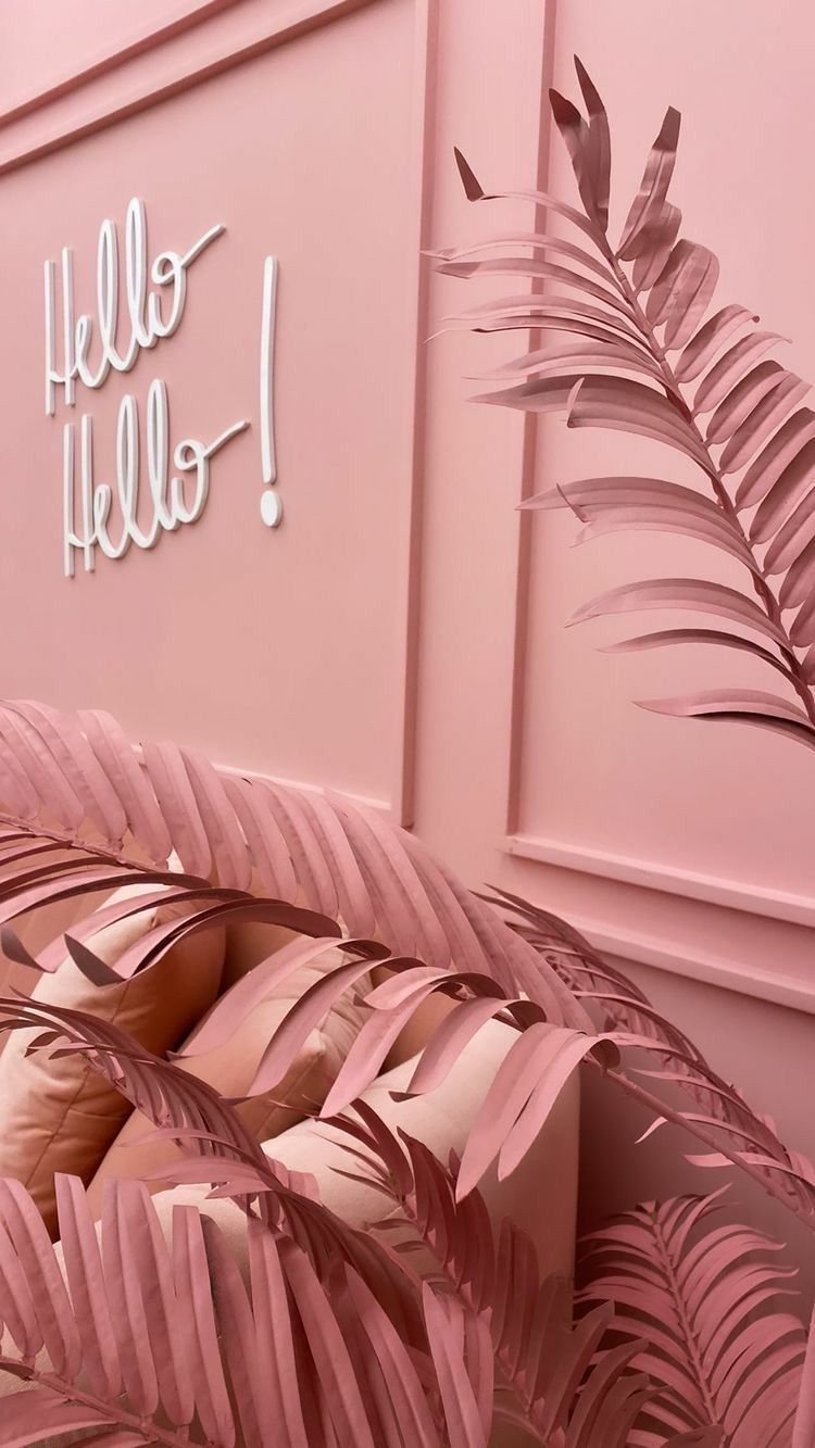 Uma parede rosa com folhas de palmeira e uma placa que diz `` olá, olá ''.