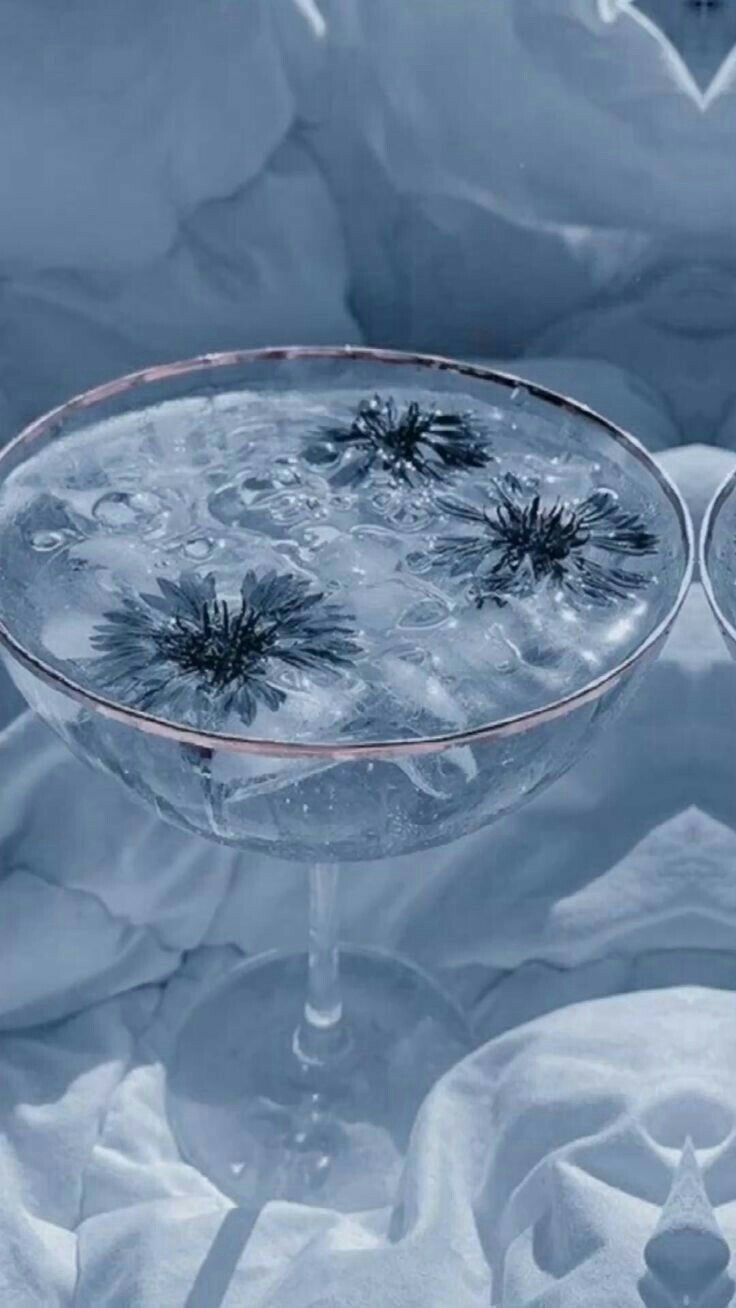 Uma taça de martini cheia de água e flores sobre uma mesa.