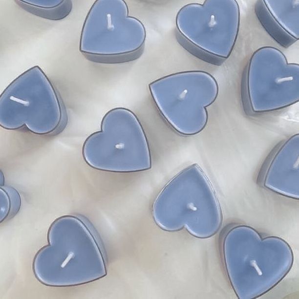 Um monte de velas em forma de coração sobre uma mesa