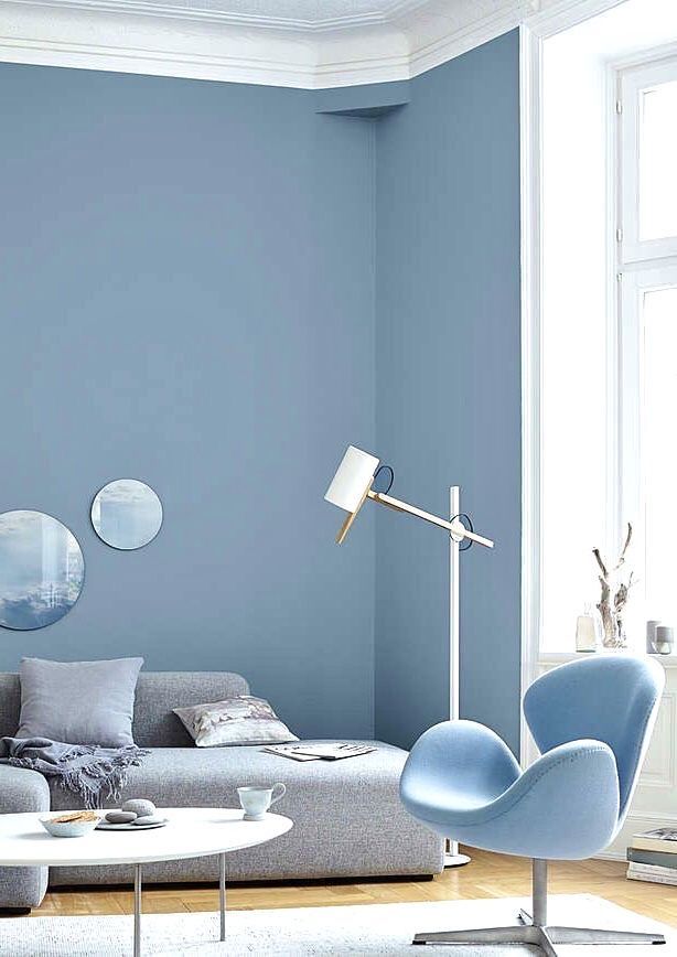 Uma sala de estar com paredes azuis e uma cadeira azul