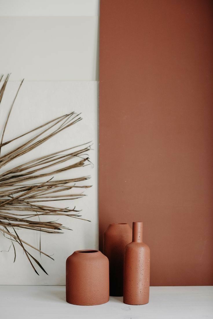 Três vasos estão sobre uma mesa ao lado de uma planta.