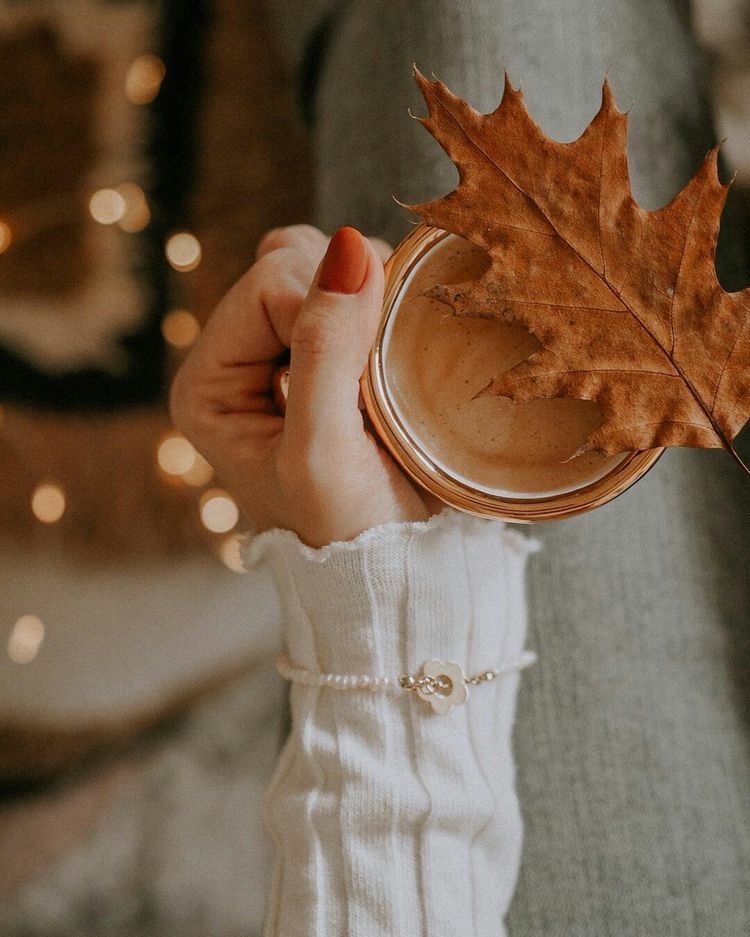 Uma mulher está segurando uma xícara de café e uma folha de bordo.