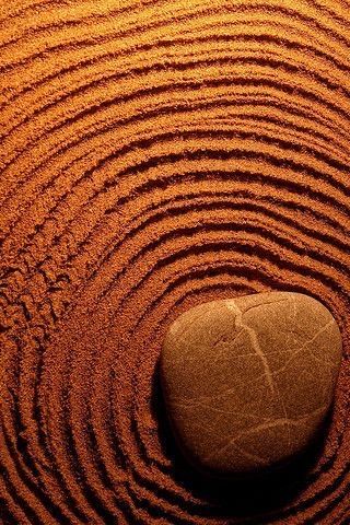 Uma pedra está no meio de um círculo de areia.