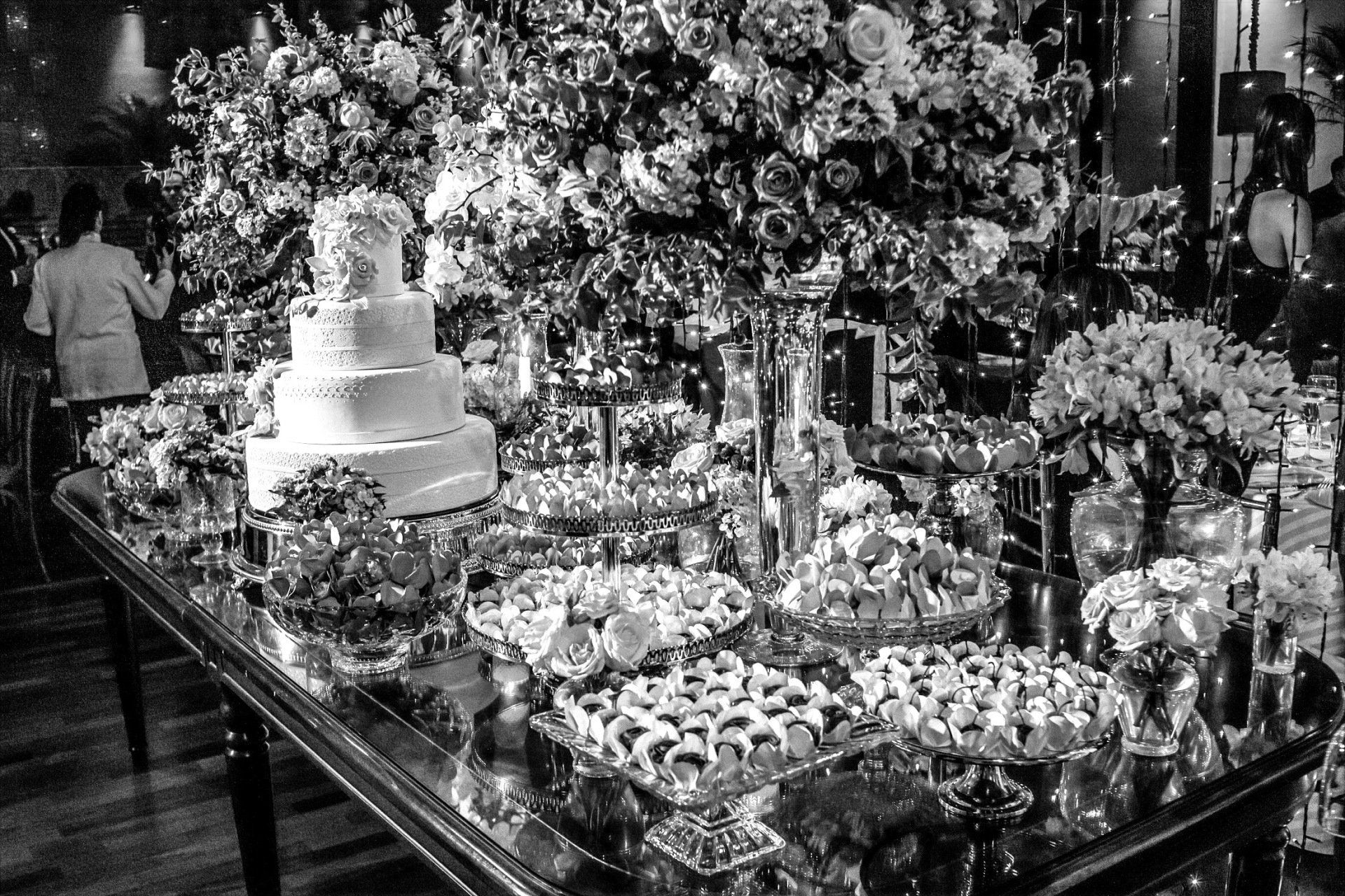 Uma foto em preto e branco de uma mesa com um bolo em cima.