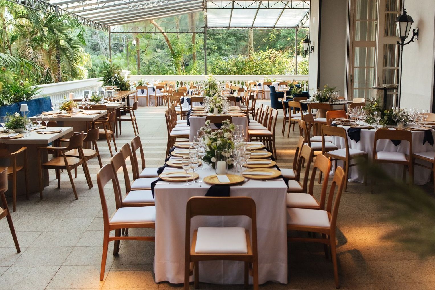 Um restaurante com mesas e cadeiras preparadas para uma recepção de casamento.