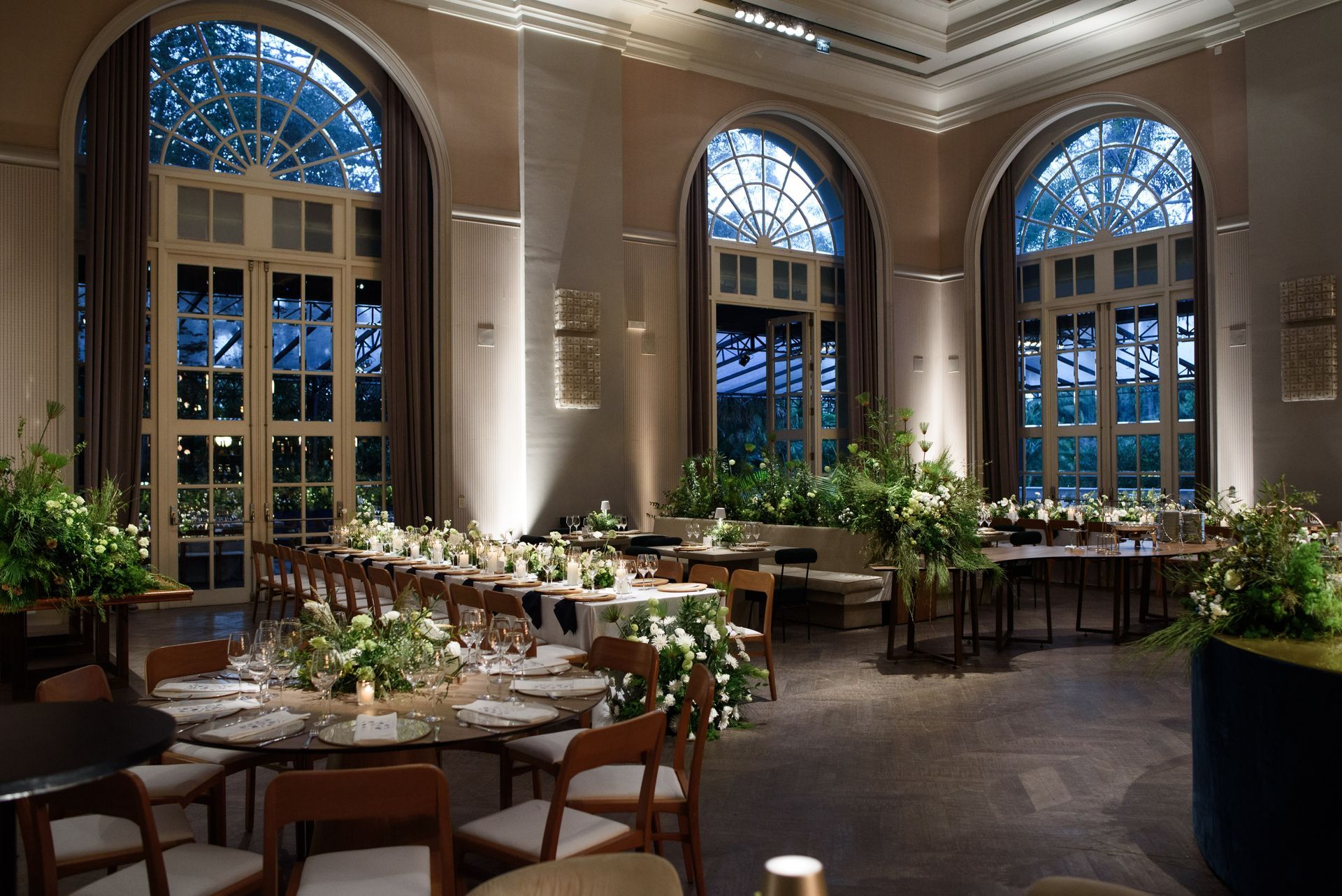Uma sala grande com mesas e cadeiras e muitas janelas