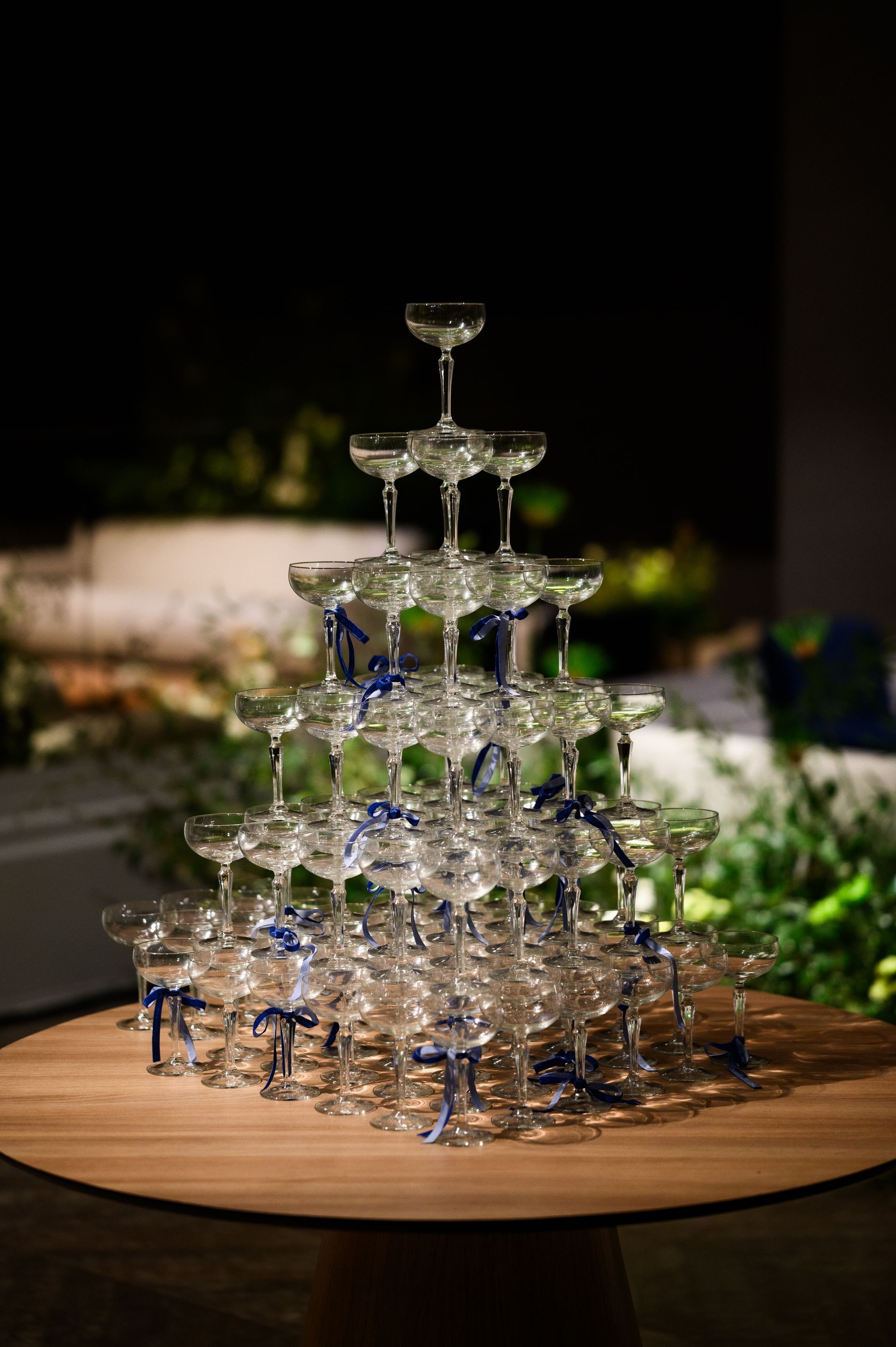 Uma pirâmide de taças de champanhe sobre uma mesa de madeira.