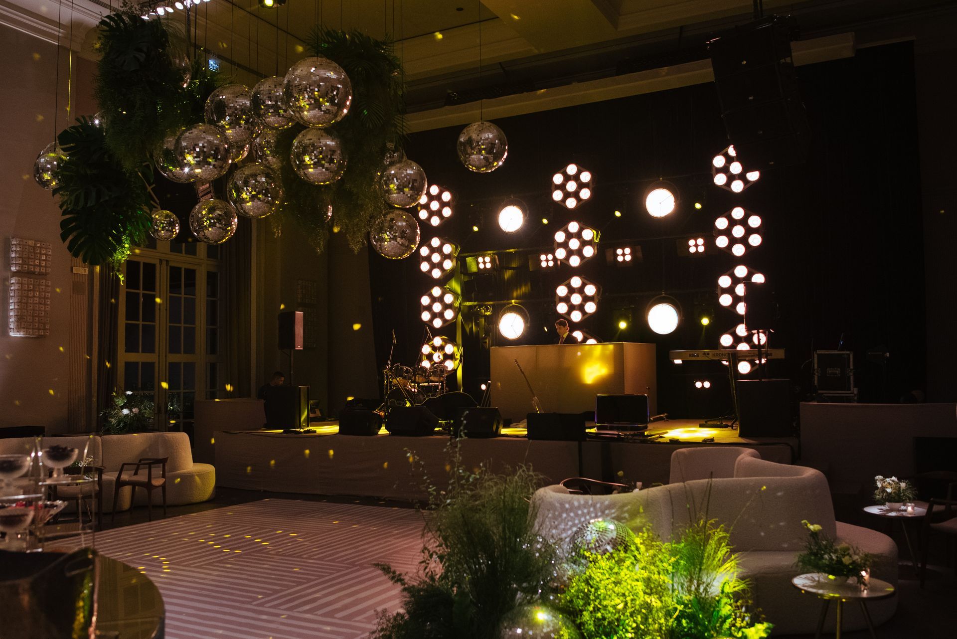 Uma sala grande com pista de dança e bolas de discoteca penduradas no teto.