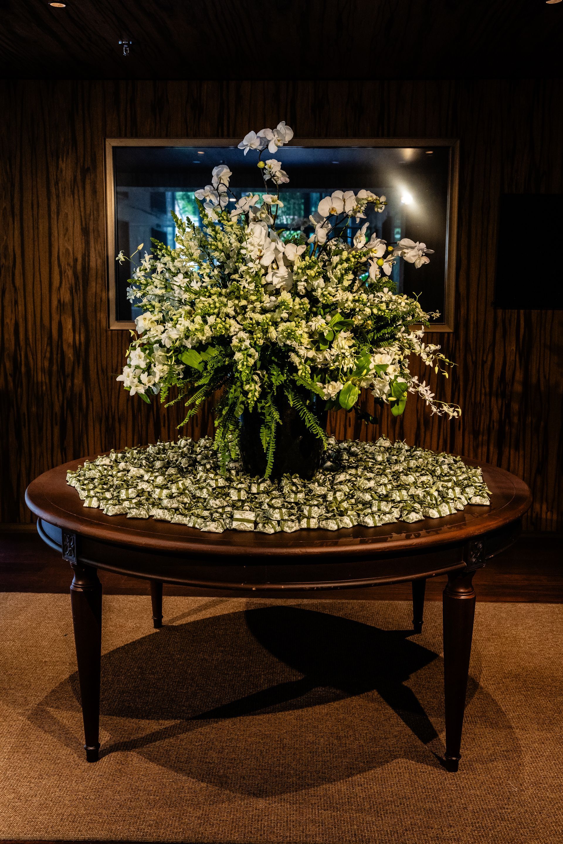 Uma mesa com um vaso de flores em cima dela.