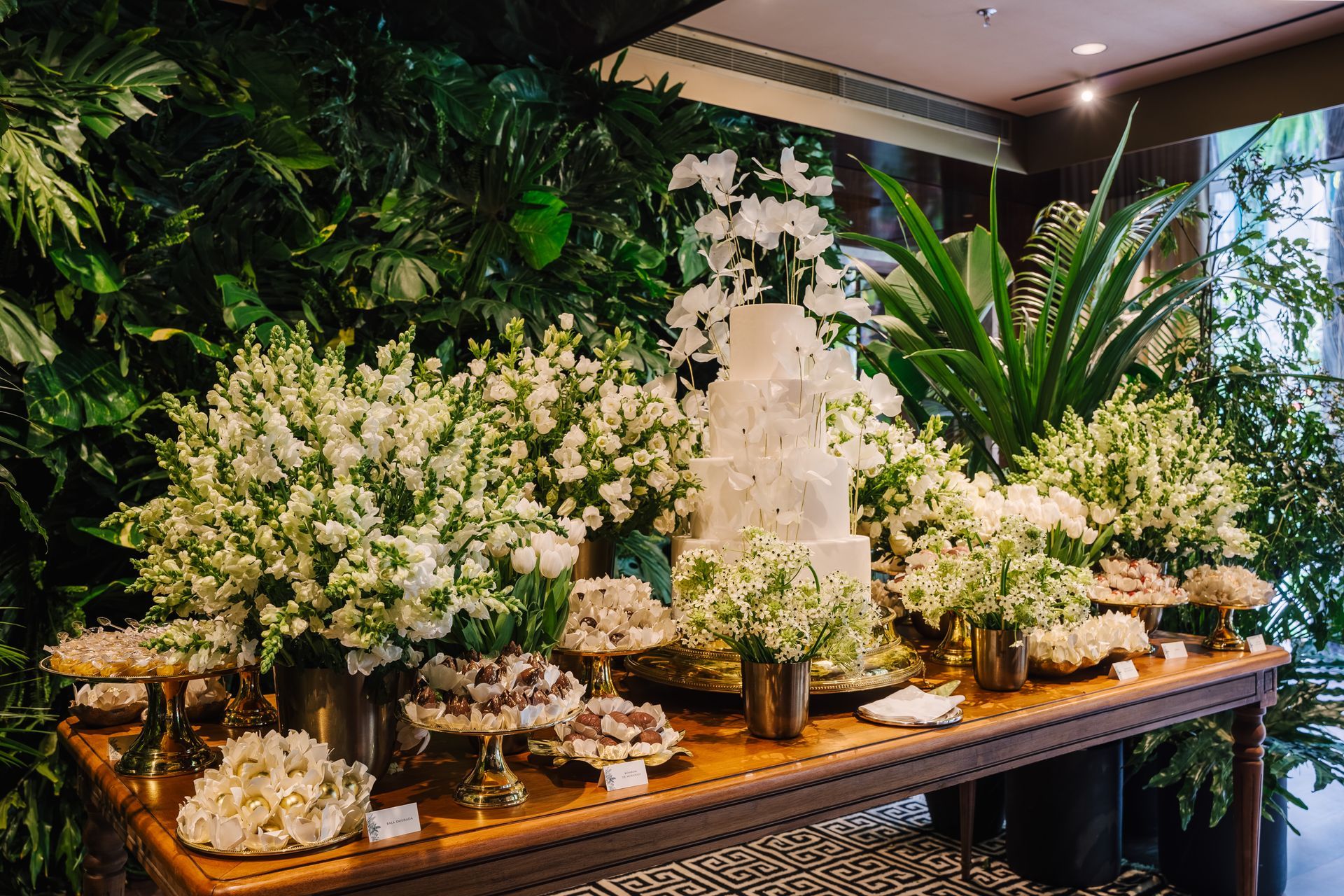 Uma mesa cheia de flores brancas e um bolo.