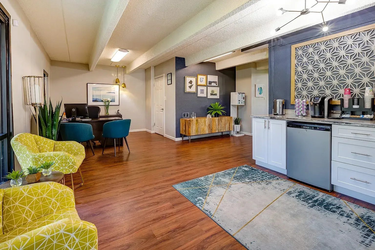 Modern apartment interior with wooden floors, kitchenette, dining area, and colorful chairs