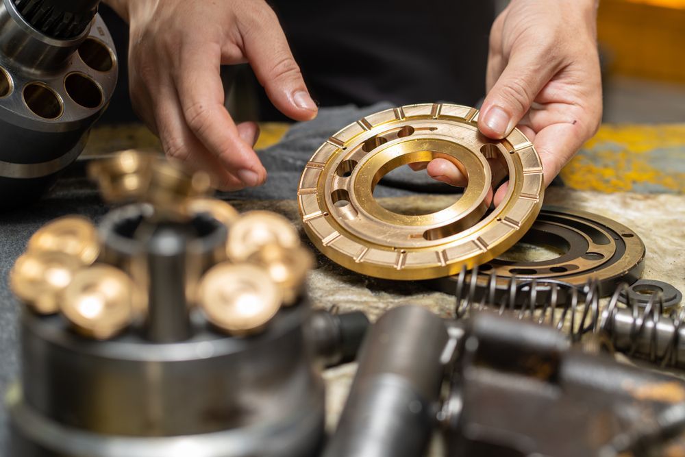 Skilled Engineer Holding A Valve Plate In A Hydraulic Workshop — Coastal Hydraulics & Engineering Pty Ltd In Bungalow, QLD