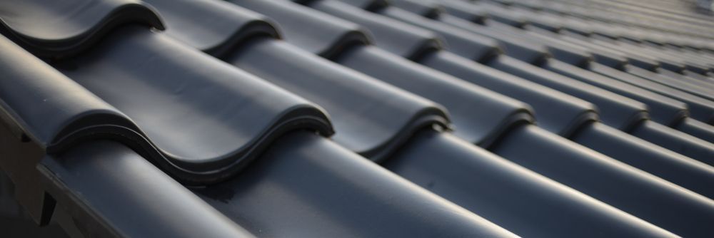 Close-up of a dark grey tiled roof with curved edges, diagonally aligned— Richmond Roof Tiling in Ballina, NSW