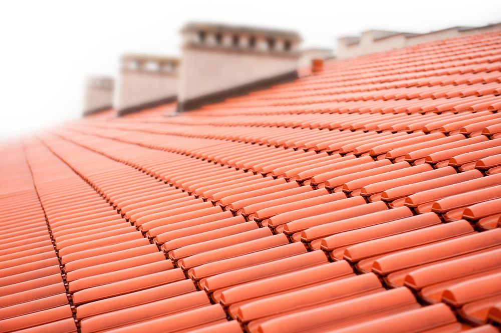 Red Ceramic Tile Roof with Chimneys in The Background — Richmond Roof Tiling in Ballina, NSW