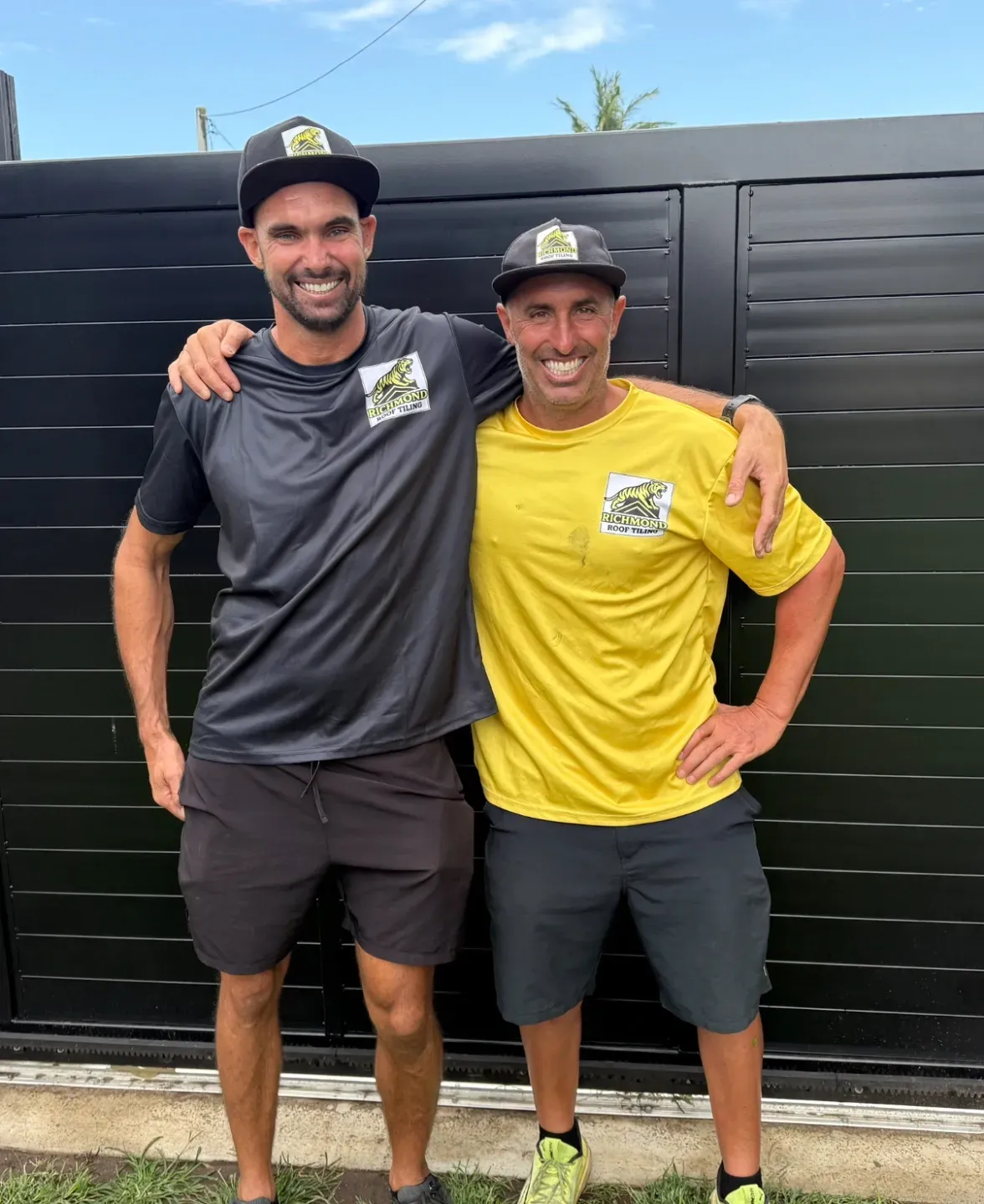 Two Men in Matching Hats and Shirts Pose — Richmond Roof Tiling in Ballina, NSW
