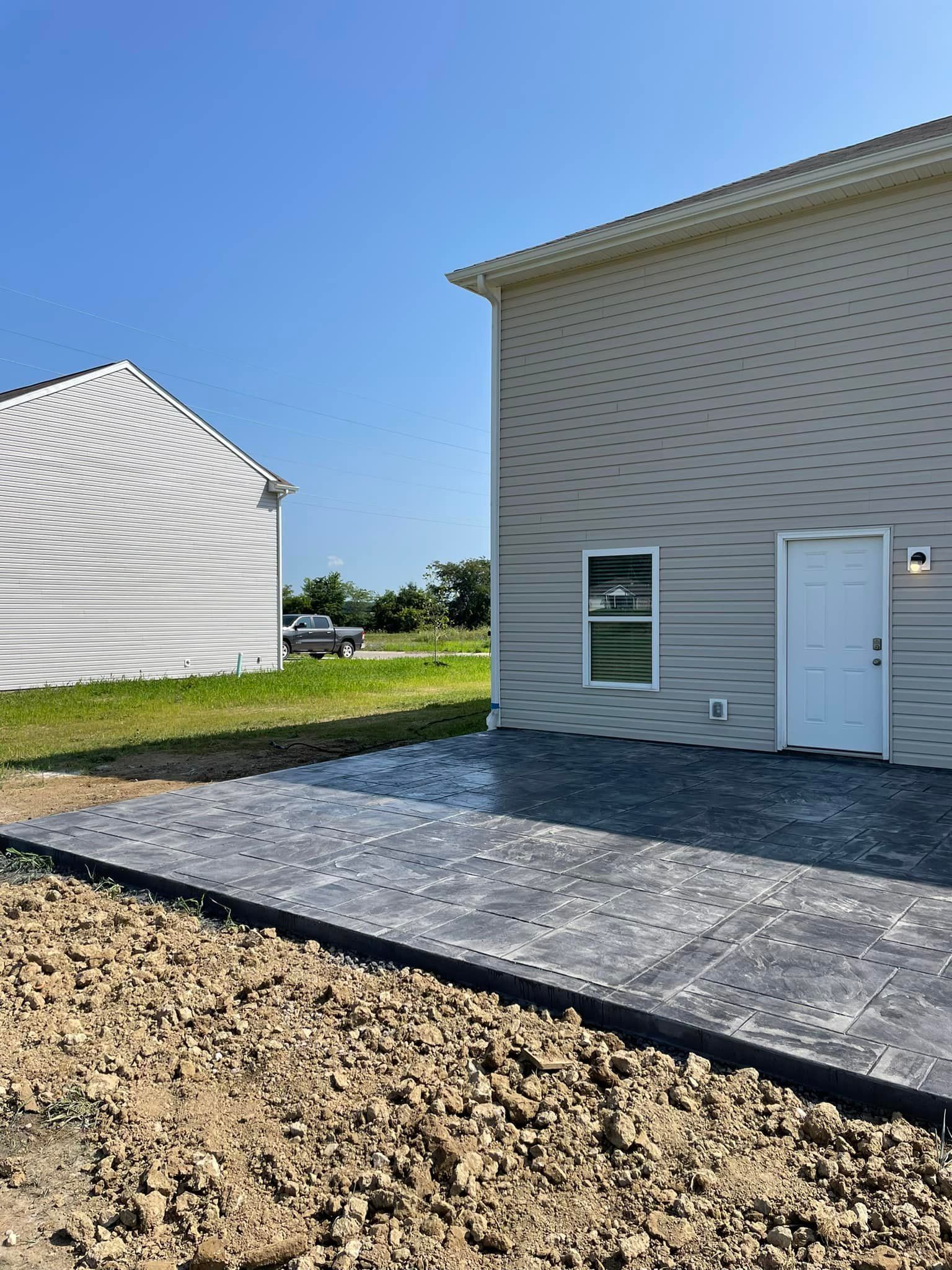 A house with a concrete driveway in front of it.