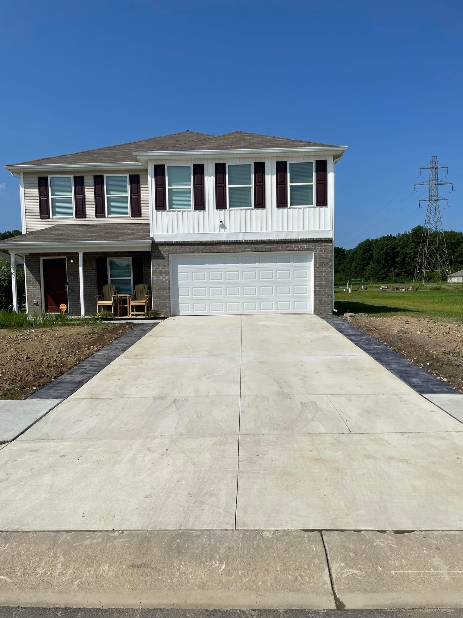 A large house with a concrete driveway leading to it