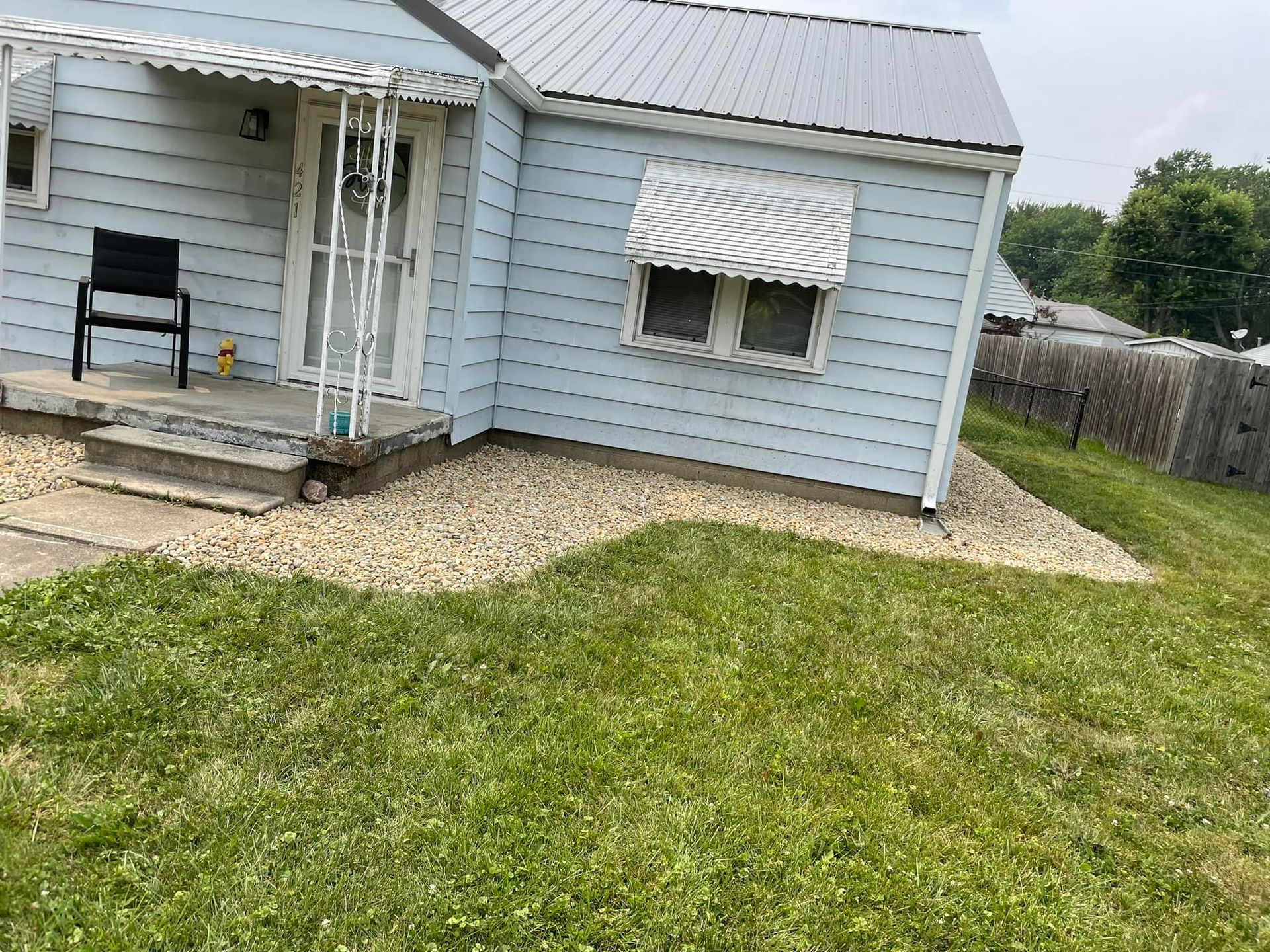 A small house with a large lawn in front of it.