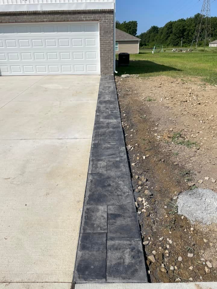 A sidewalk is being built next to a garage door.
