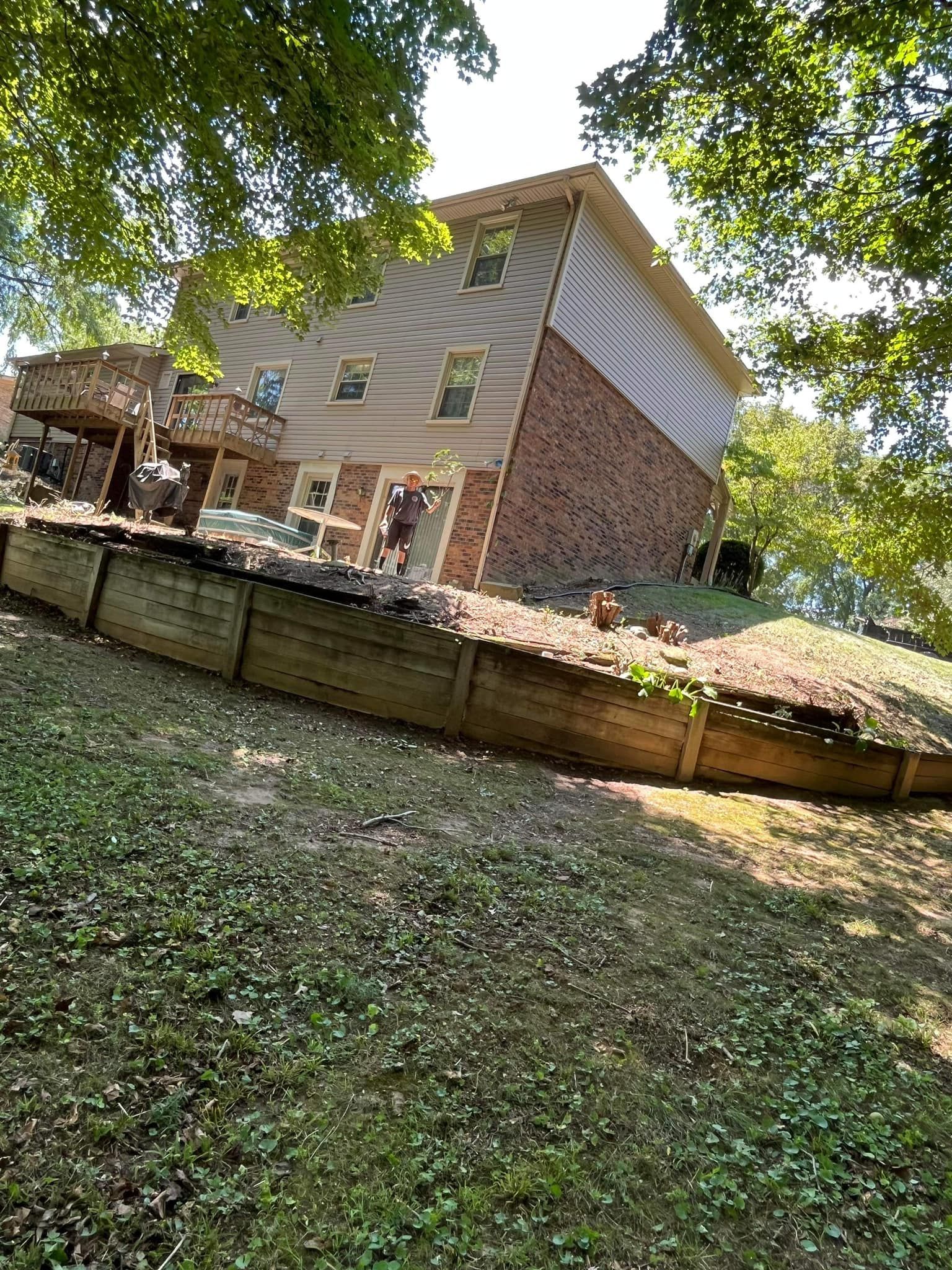 A large brick house with a wooden fence in front of it.