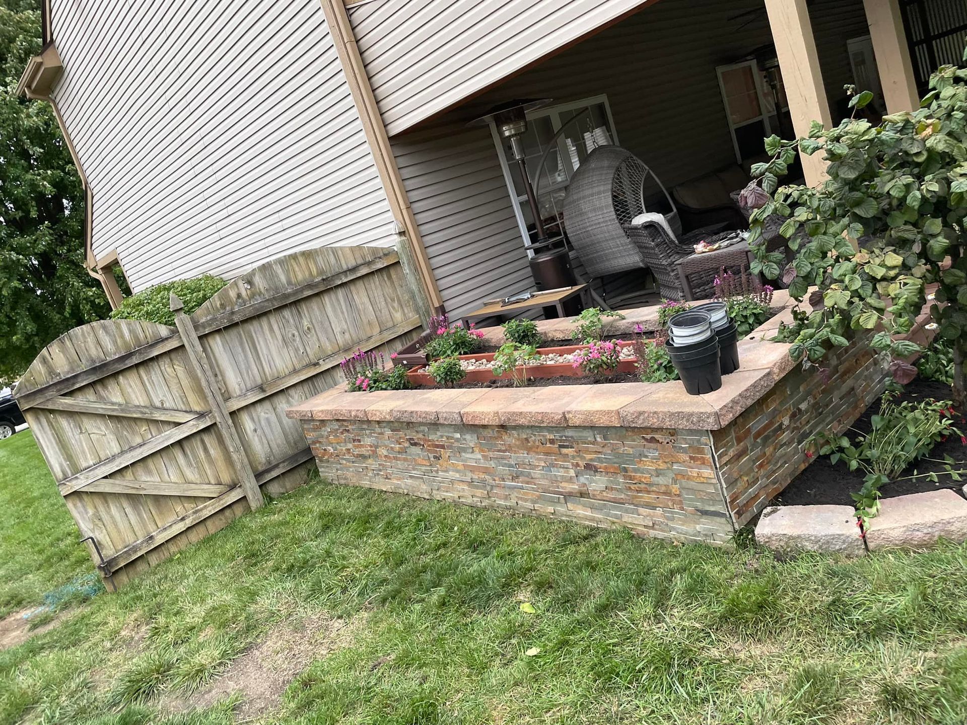 There is a brick wall in the backyard of a house.