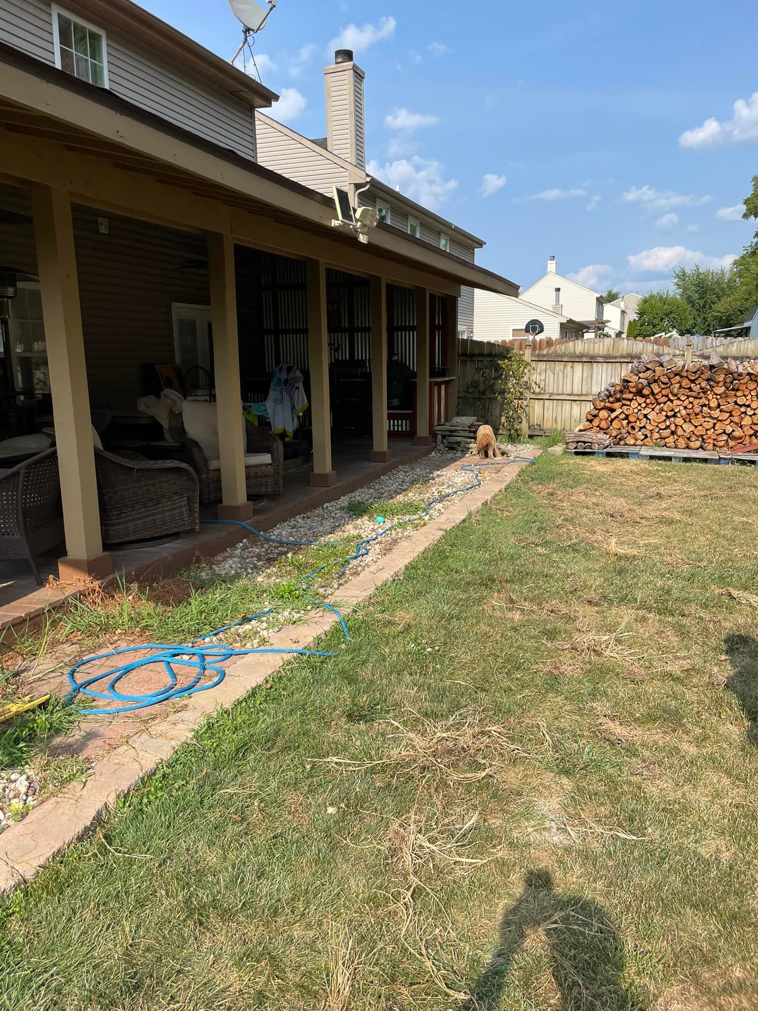A house with a porch and a large lawn in front of it.