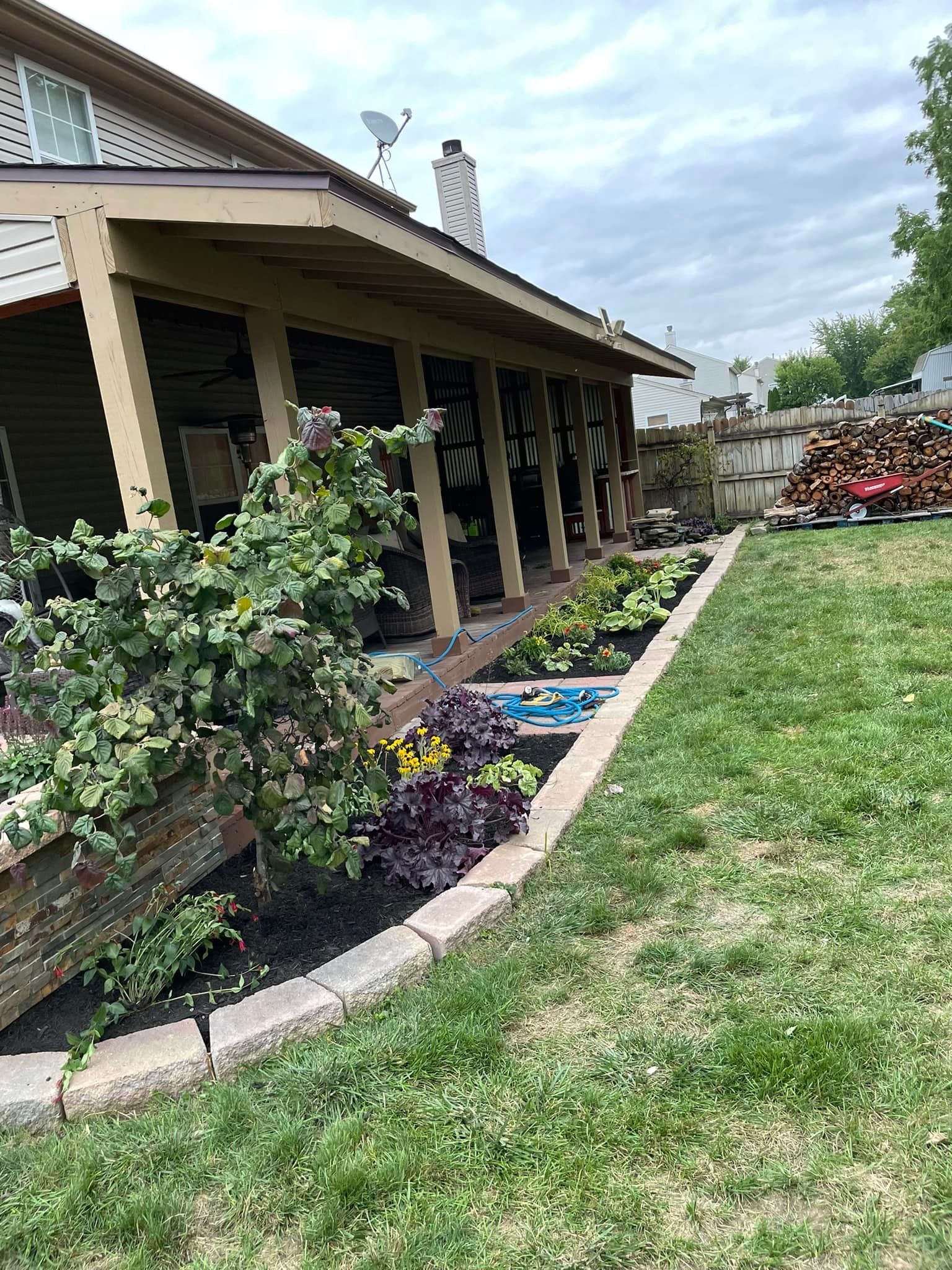 A house with a porch and a lush green lawn in front of it.