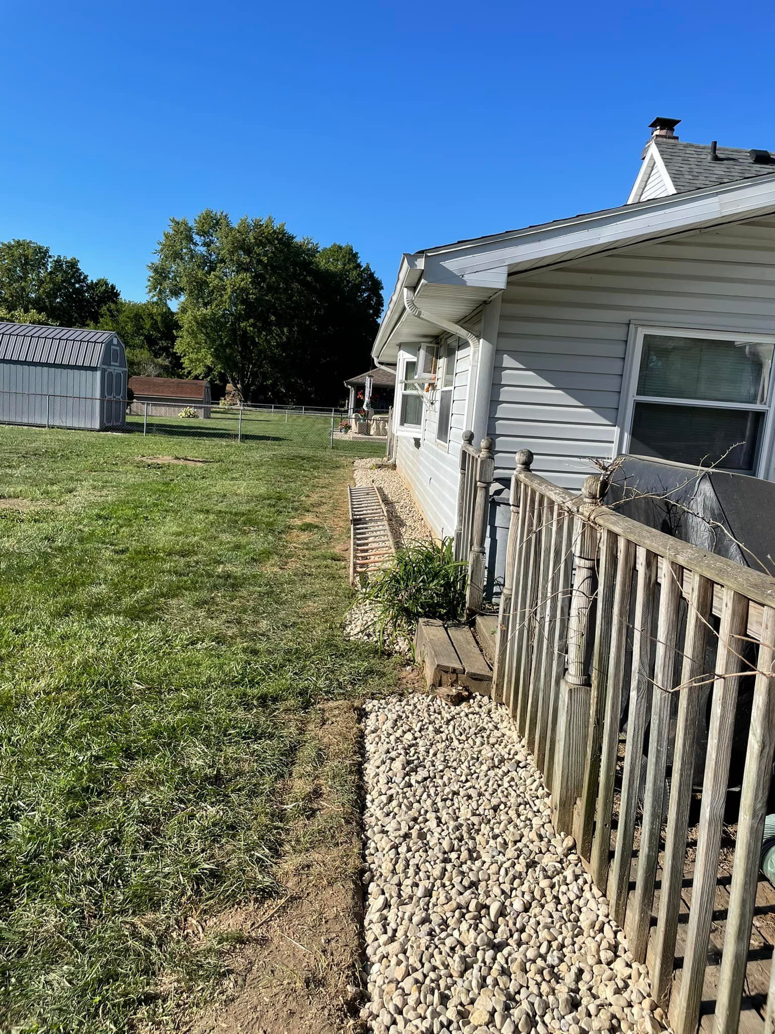 A house with a fence and a yard in front of it.