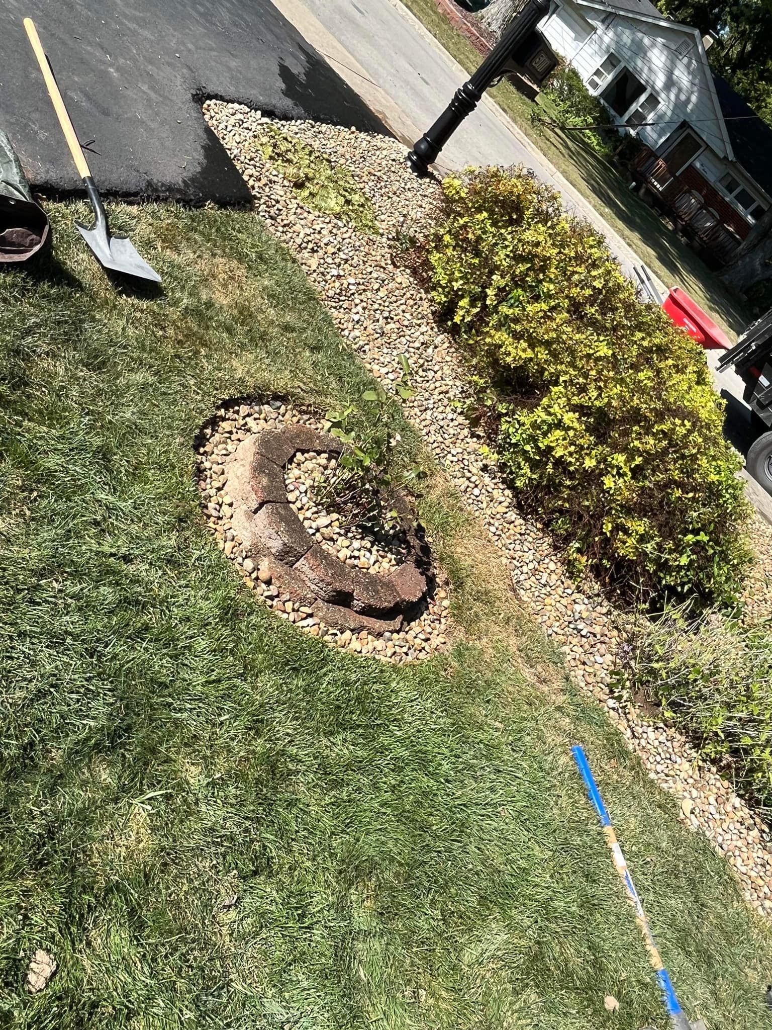 A fire pit is being built in the grass next to a road.