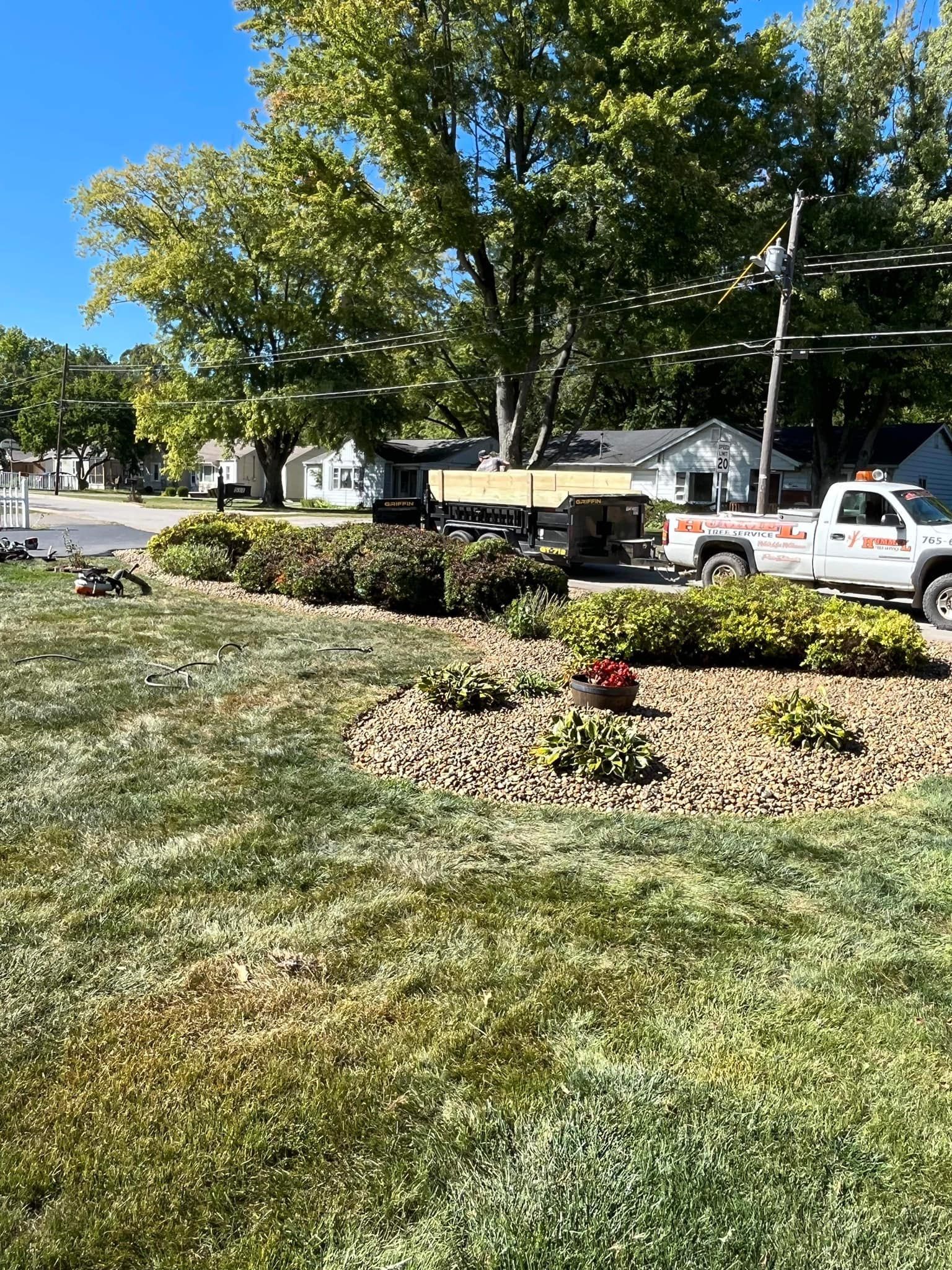 A white truck is parked in a lush green yard.