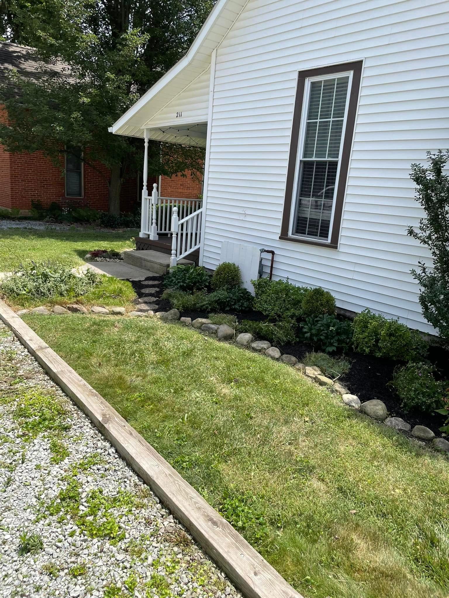 A white house with a wooden walkway leading to the front door.