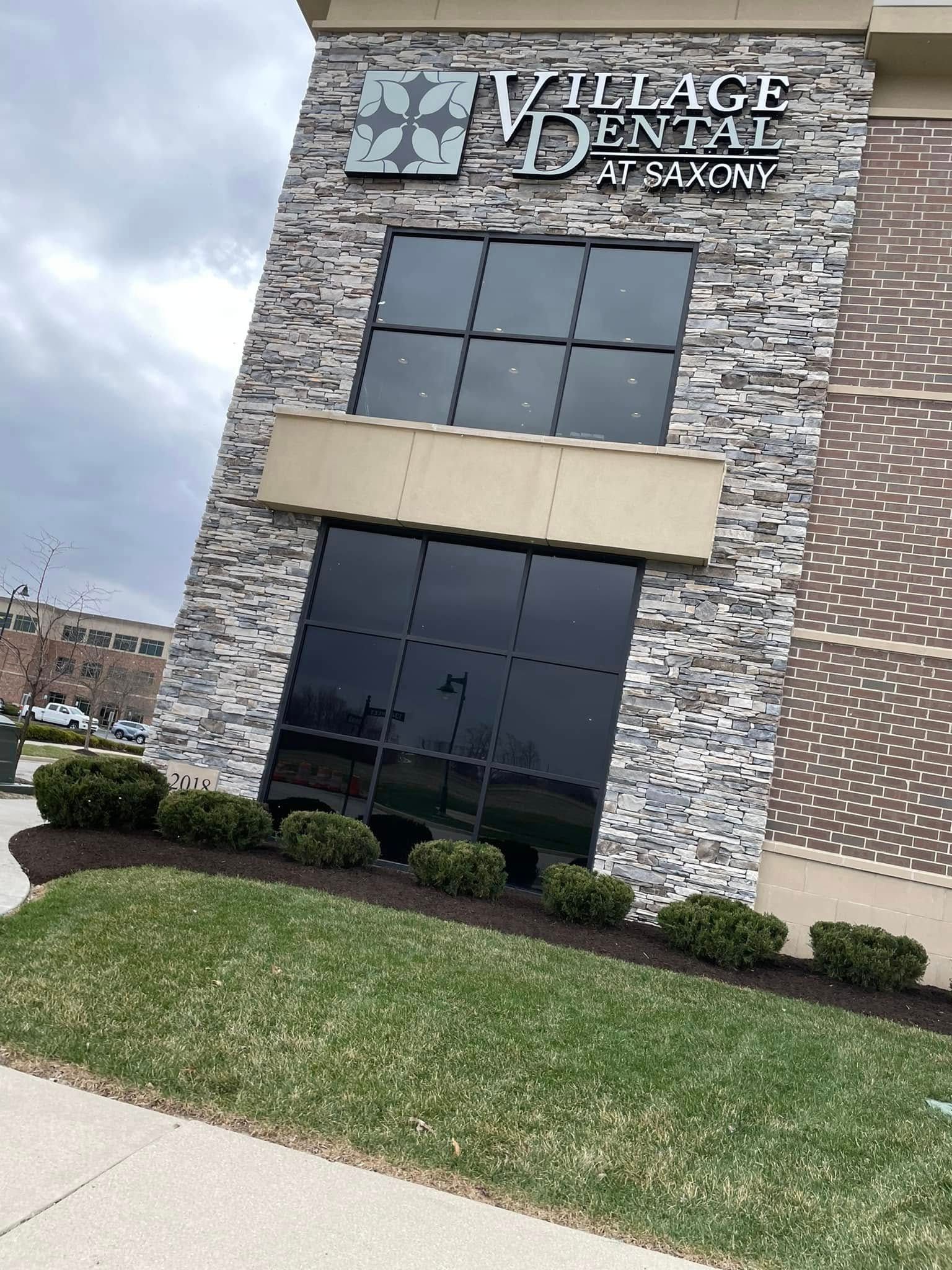 A building with a sign that says village dental at saxony