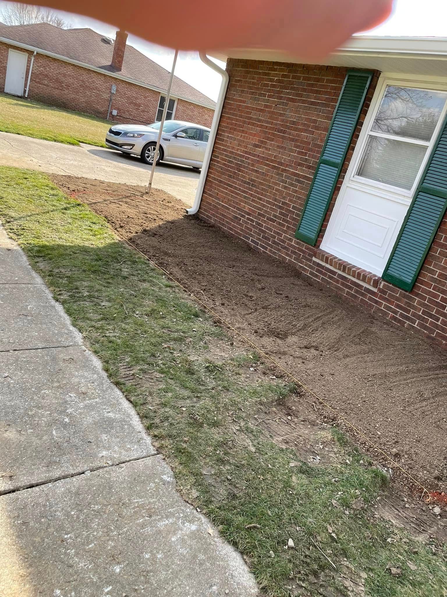 A brick house with a white car parked in front of it.