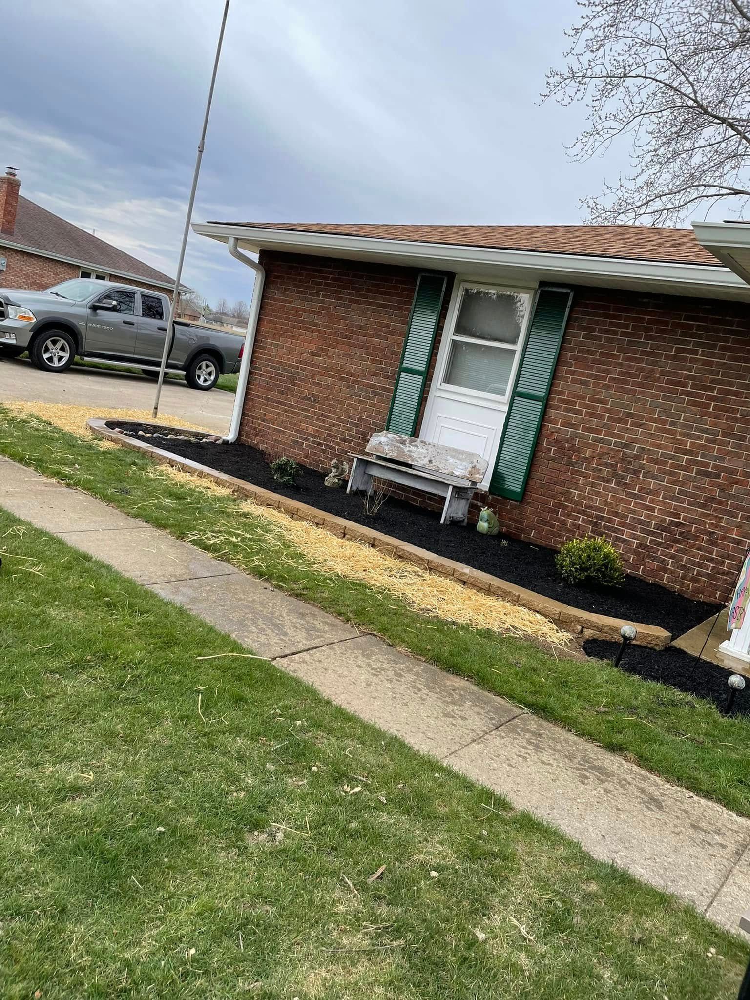 A brick house with a bench in front of it and a truck parked in front of it.