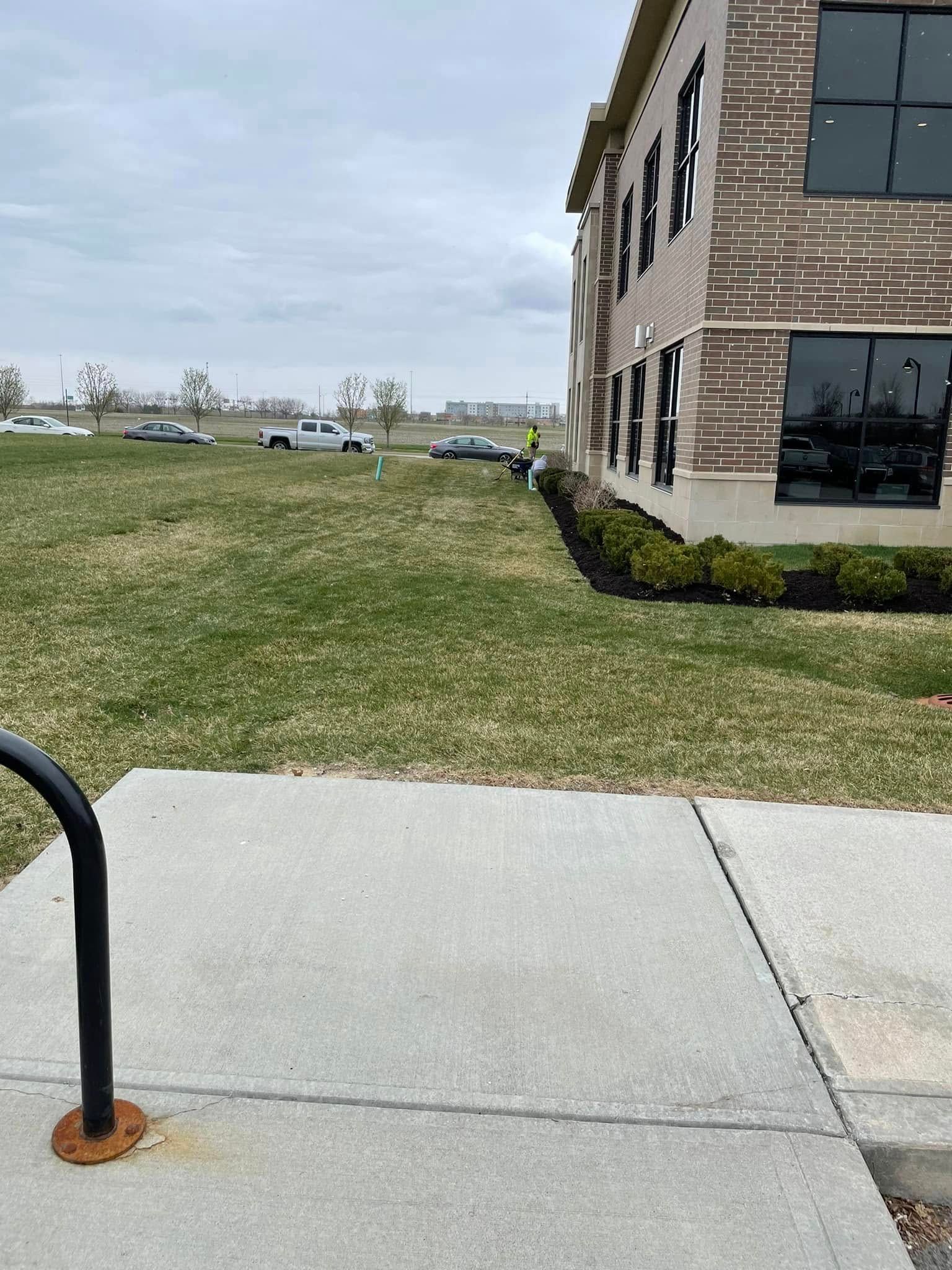 A brick building with a lush green lawn in front of it.