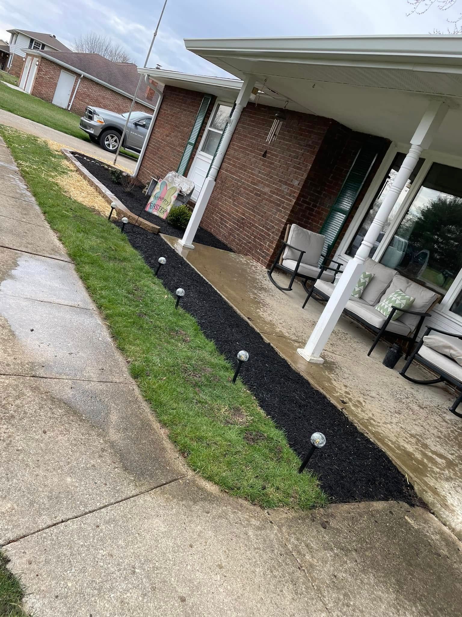 A house with a porch and a lawn in front of it.