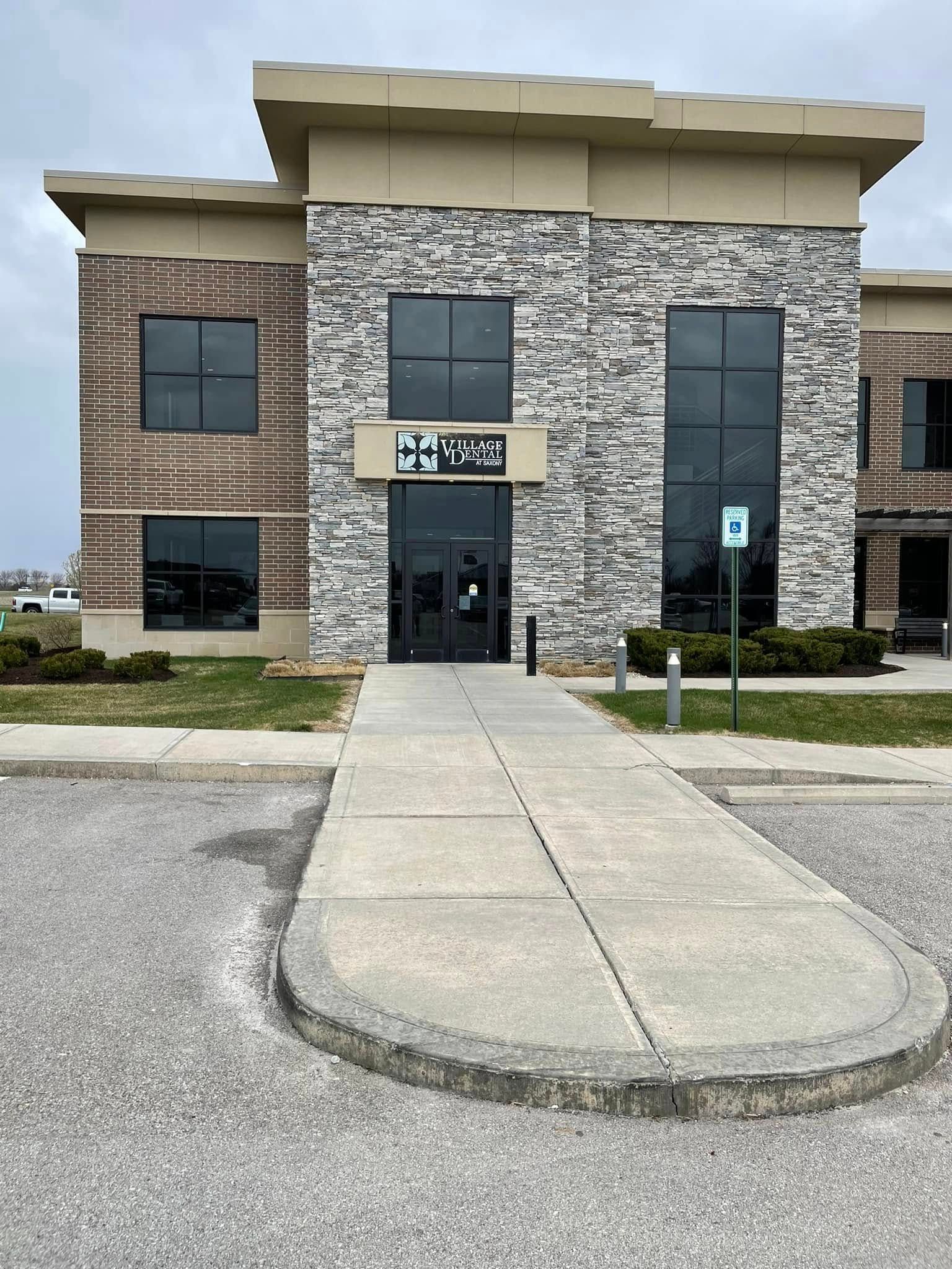 A large brick and stone building with a walkway leading to the entrance.