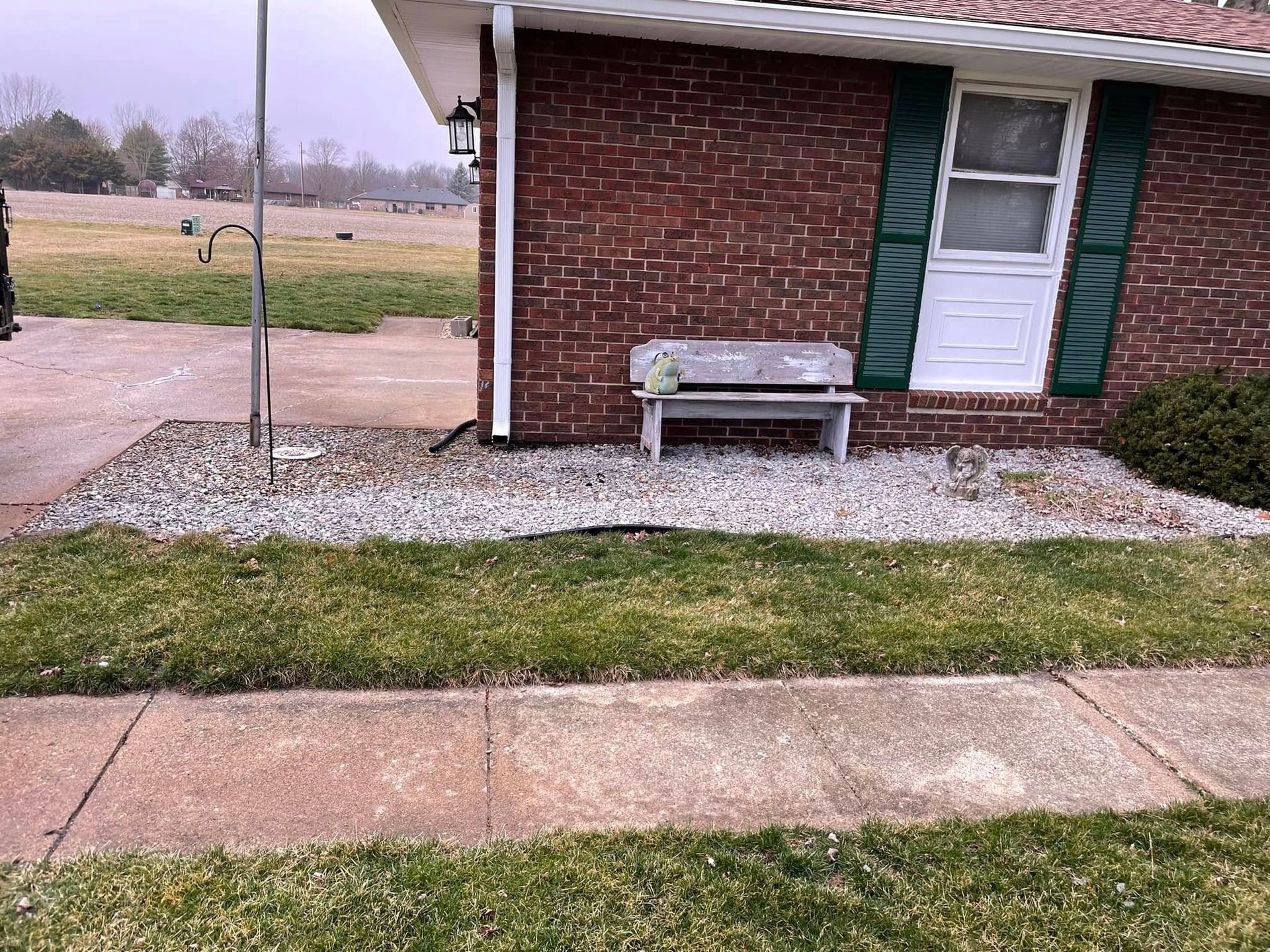 A brick house with a bench in front of it.