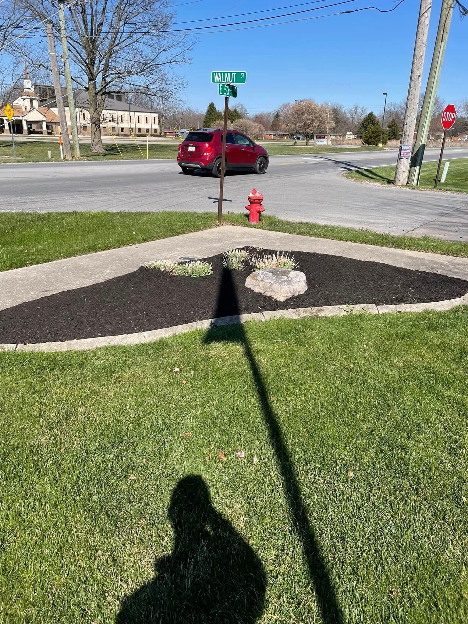 A red car is driving down a street next to a fire hydrant.