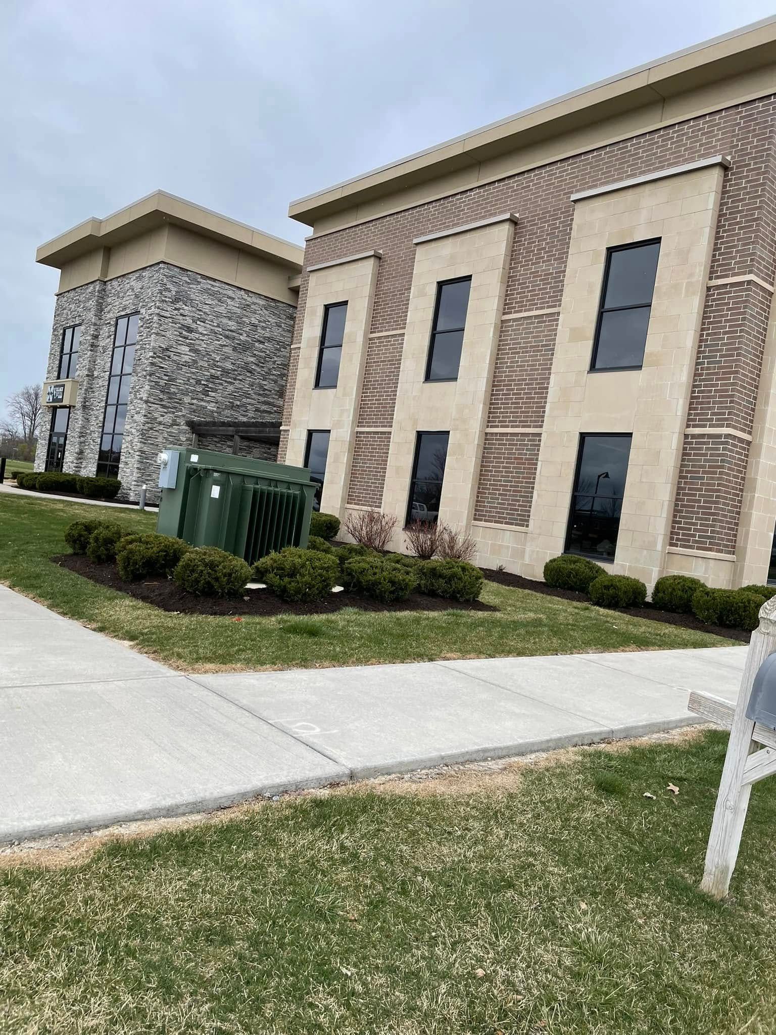 A large building with a lot of windows and a mailbox in front of it.