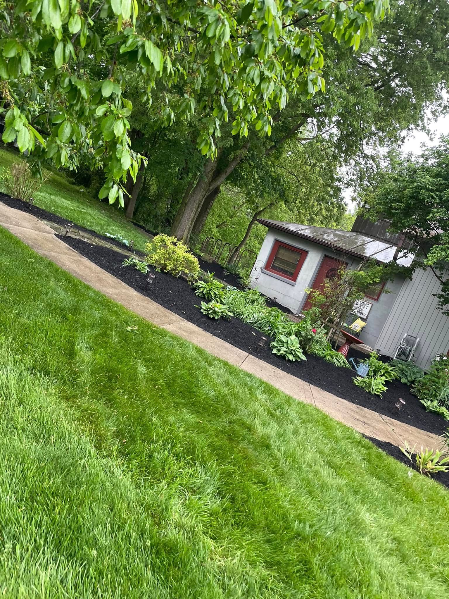 A lush green lawn with a path leading to a house.