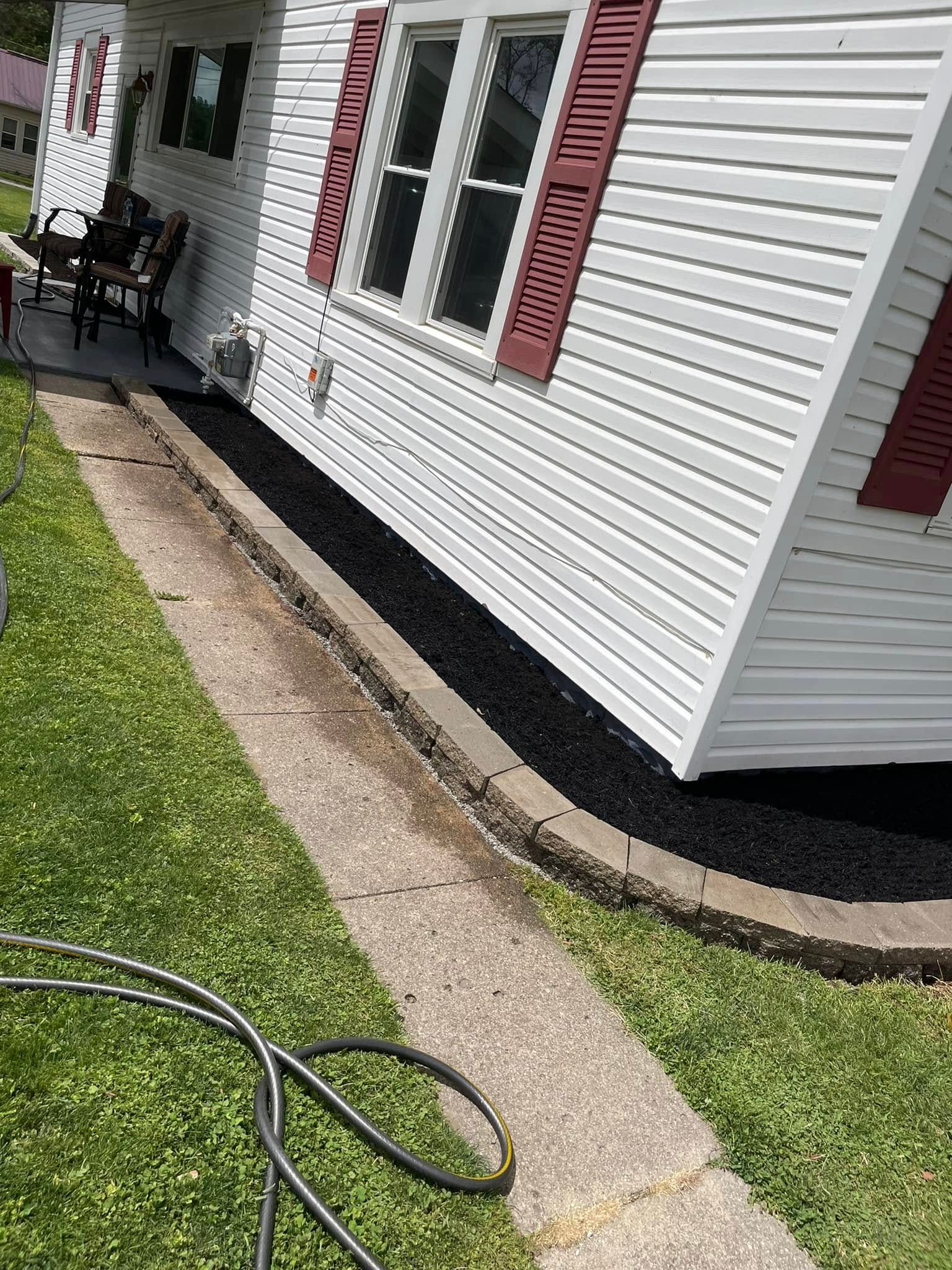 A white house with red shutters and a hose in front of it.