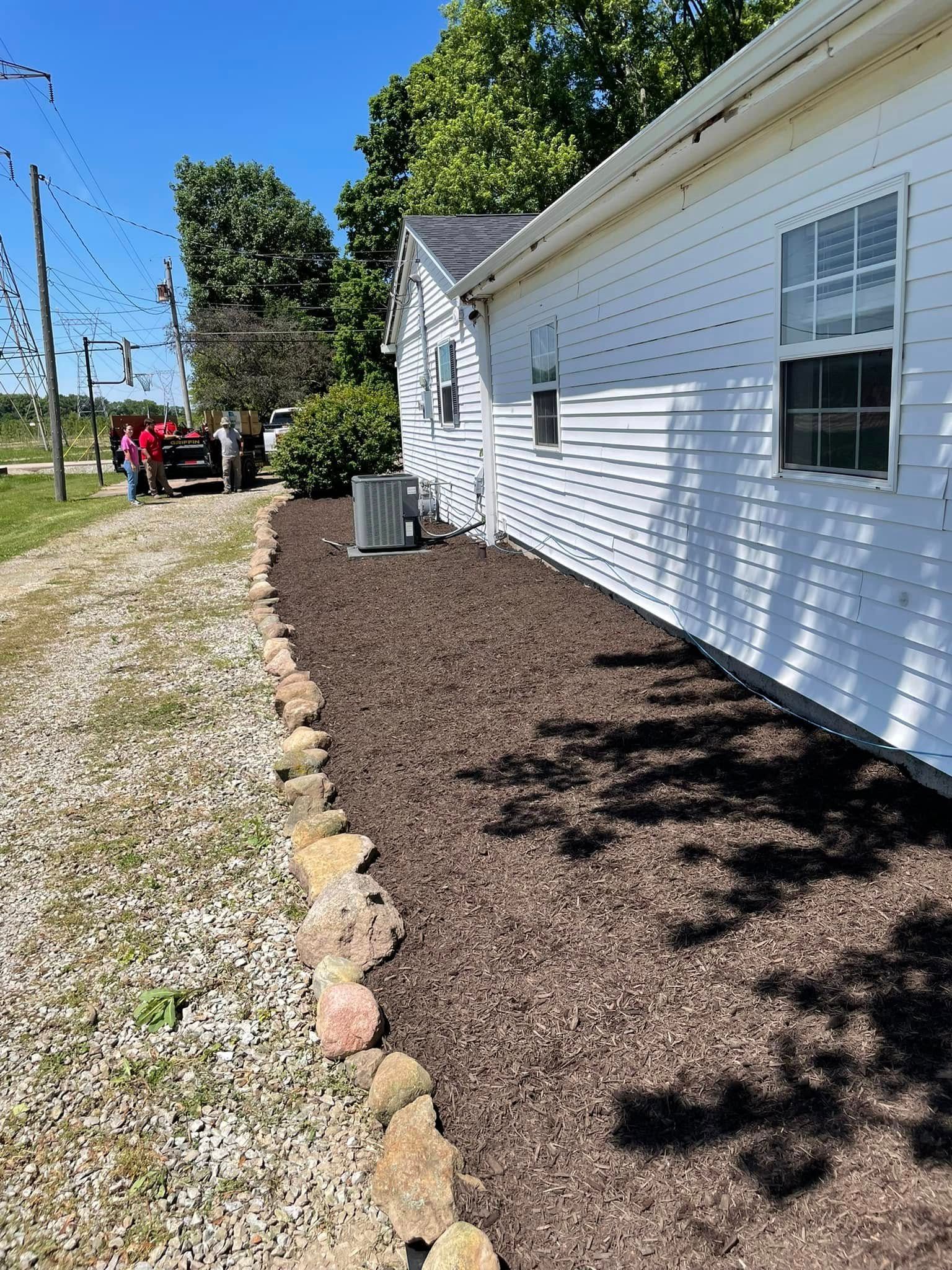 A white house with a red truck parked in front of it.