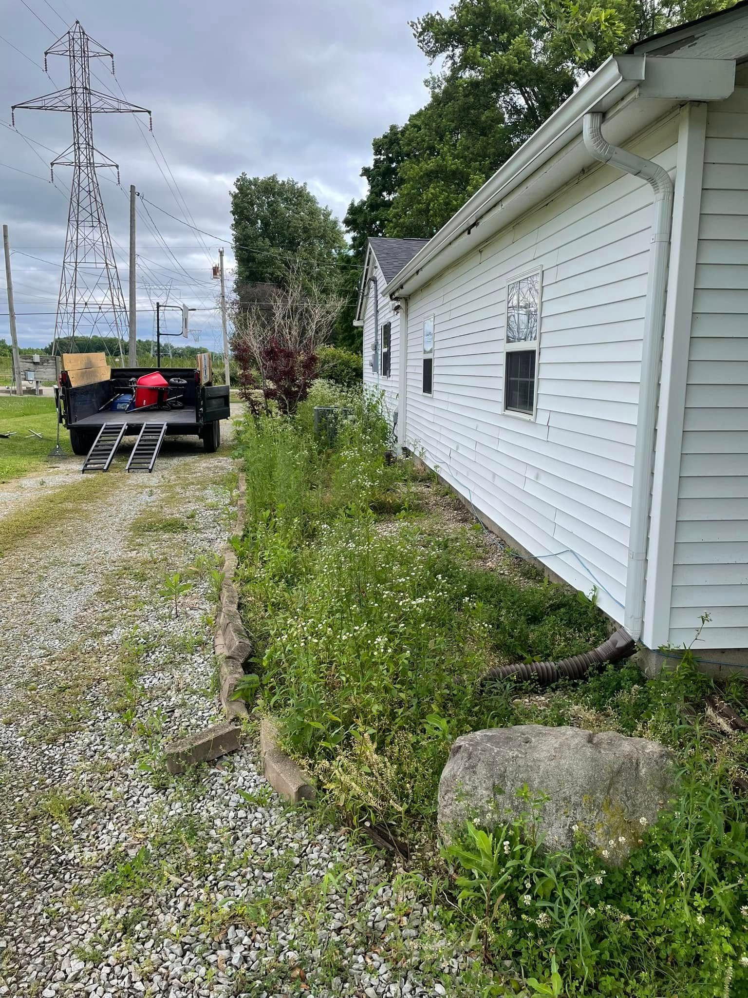 A white house with a trailer parked in front of it.