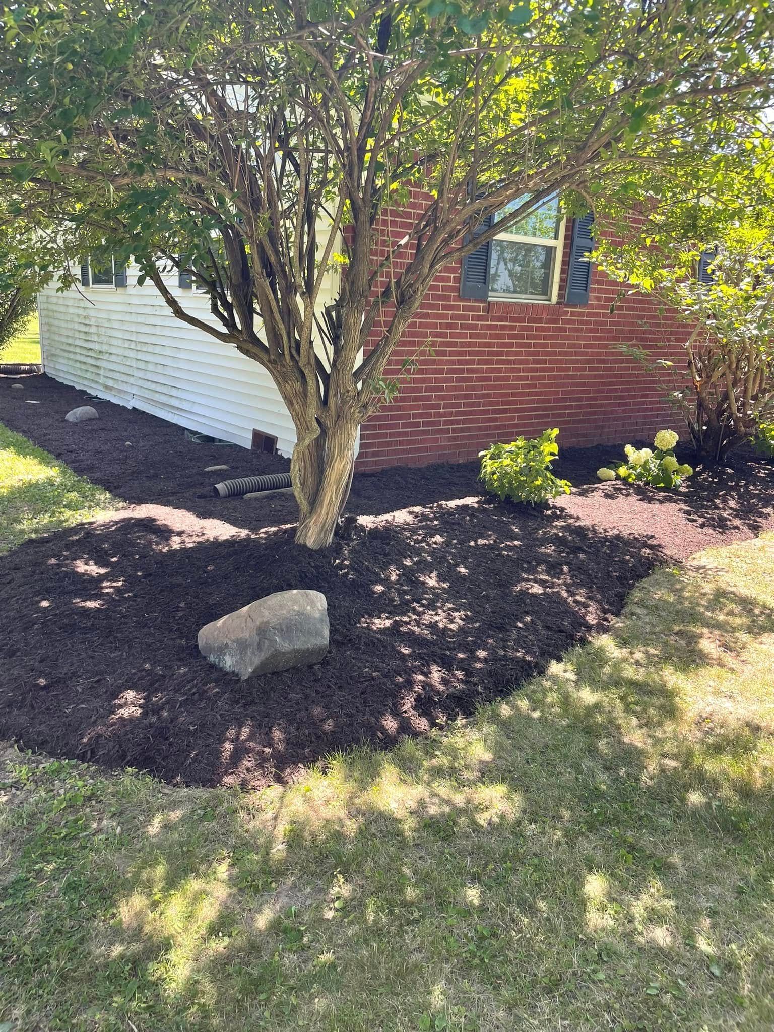 A brick house with a tree in front of it.