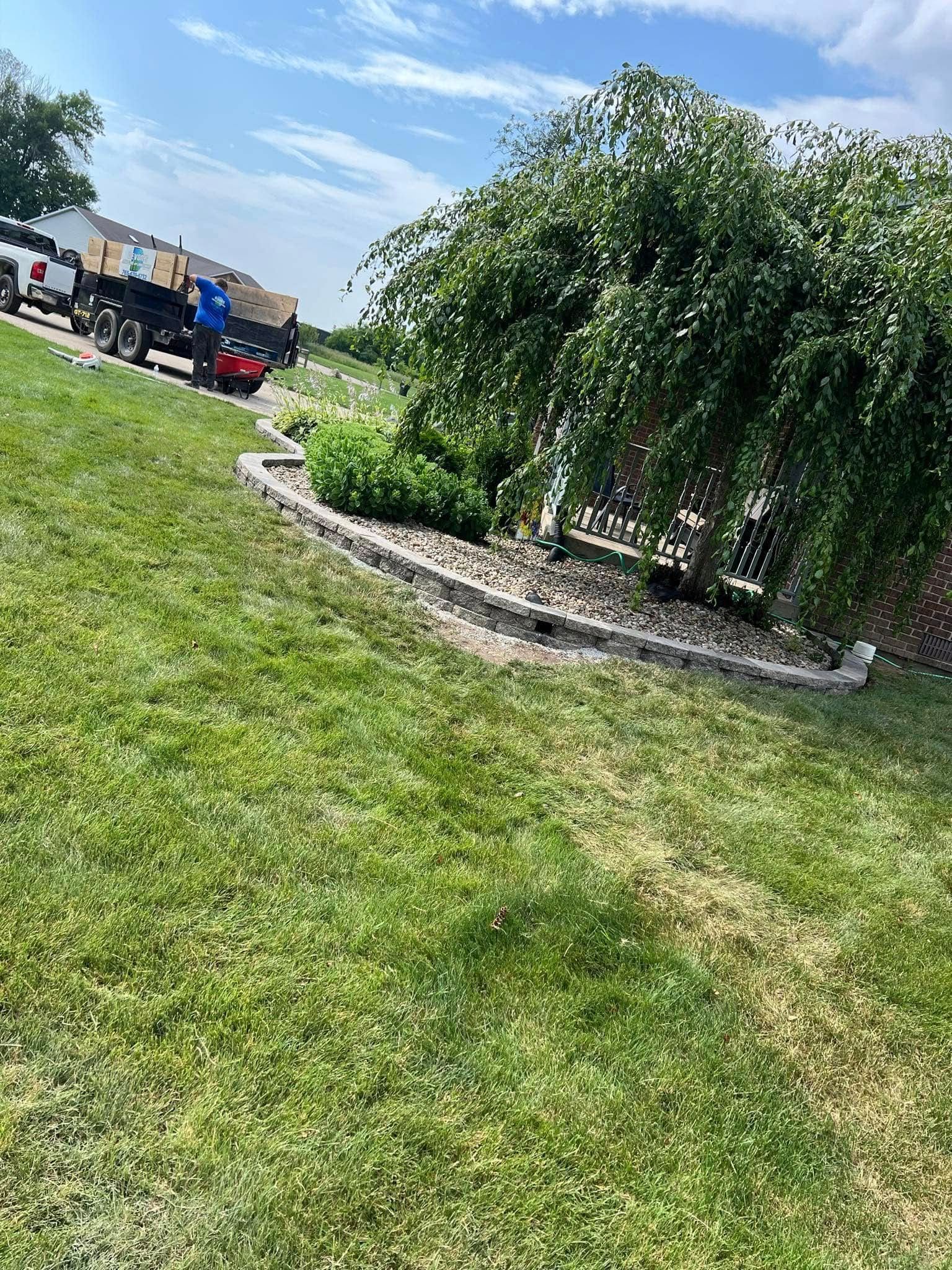 A truck is parked in the grass next to a tree.